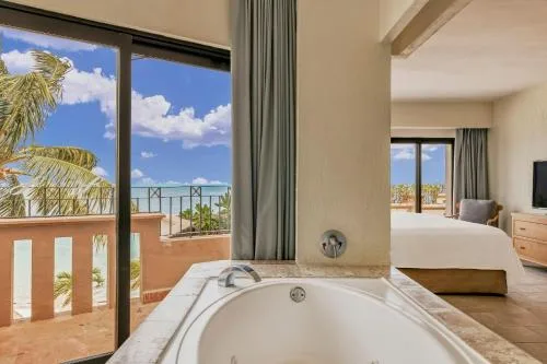Balcony-side soaking tub and bedroom view at Fiesta Americana Cancun Villas.