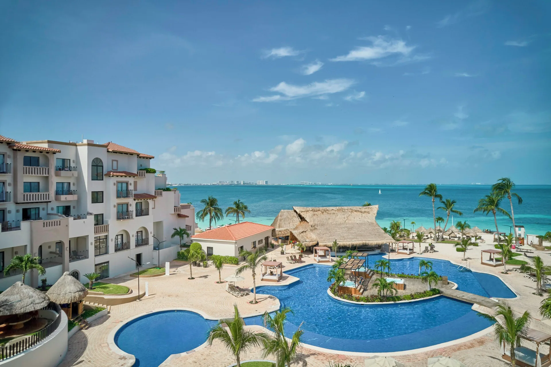 Deluxe Villa view of pools, palms, and Caribbean water at Fiesta Americana Cancun Villas.