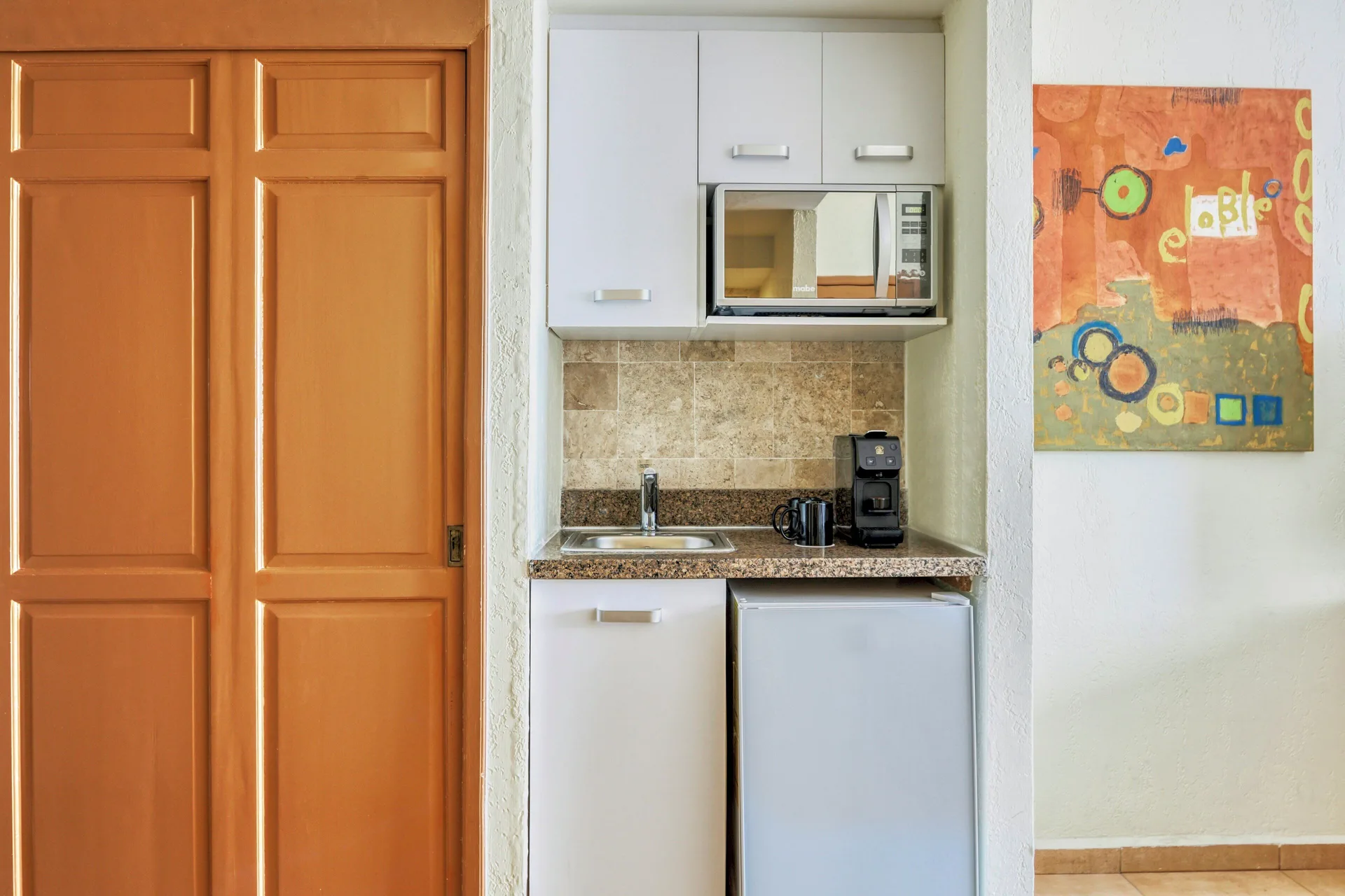 Deluxe Villa kitchenette with sink, microwave, and mini fridge at Fiesta Americana Cancun Villas.