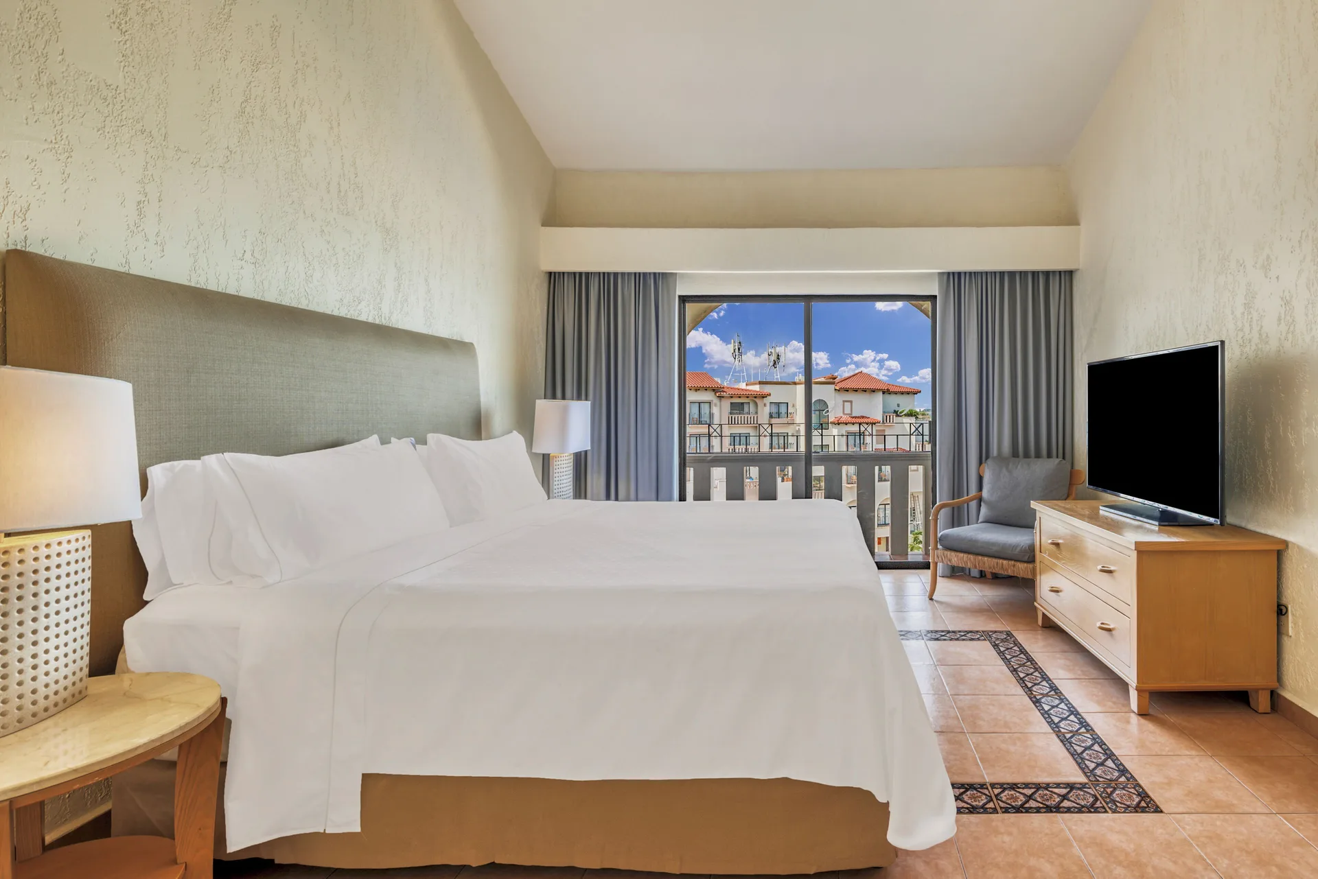 Villa Master Suite king bedroom with TV dresser and balcony at Fiesta Americana Cancun Villas.