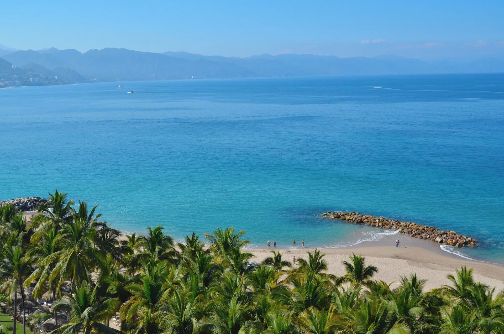 High view of the beach, palms, and blue bay at Fiesta Americana Puerto Vallarta & Spa.