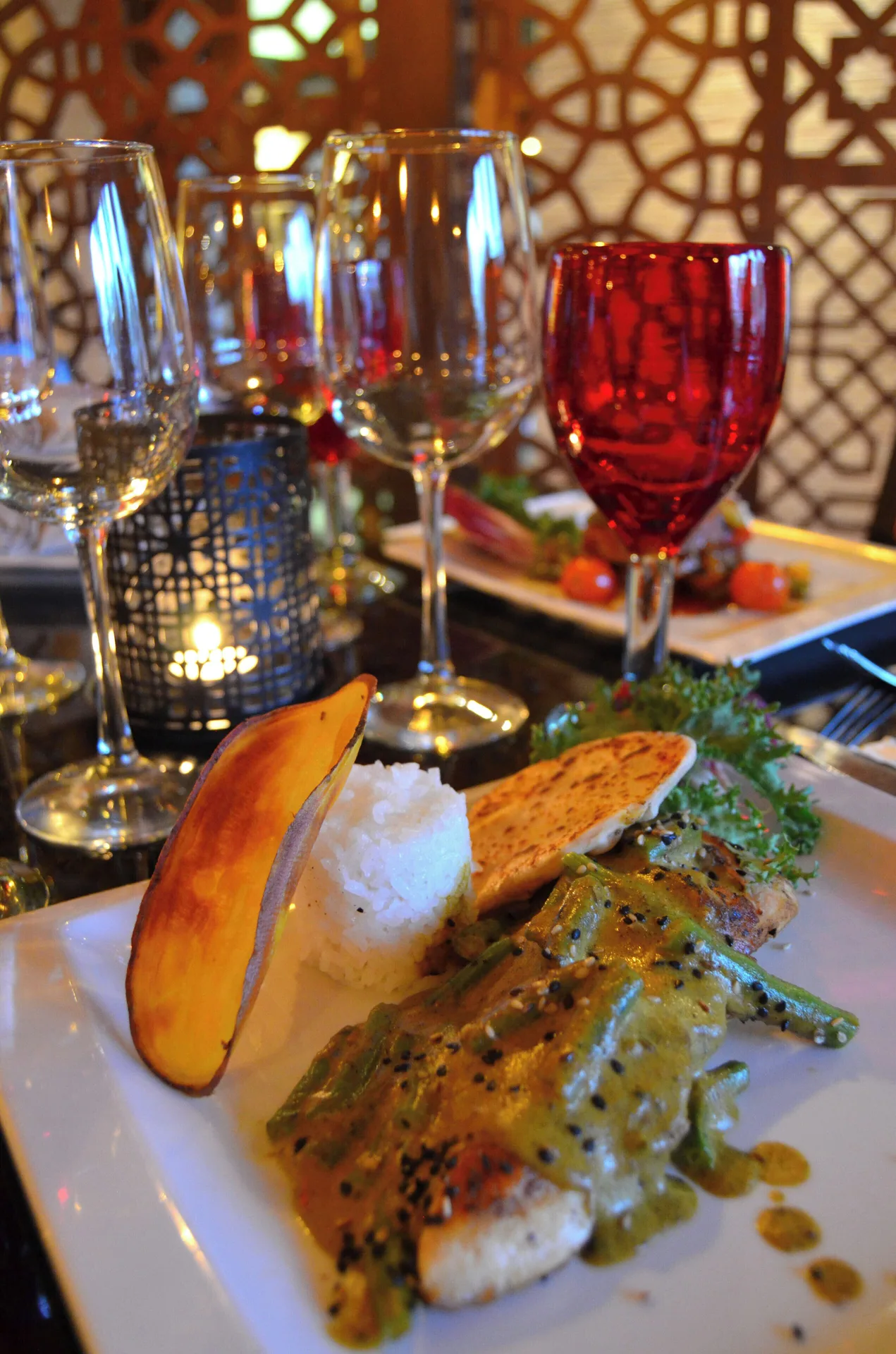 Plated seafood with rice and wine glasses at Fiesta Americana Puerto Vallarta & Spa.