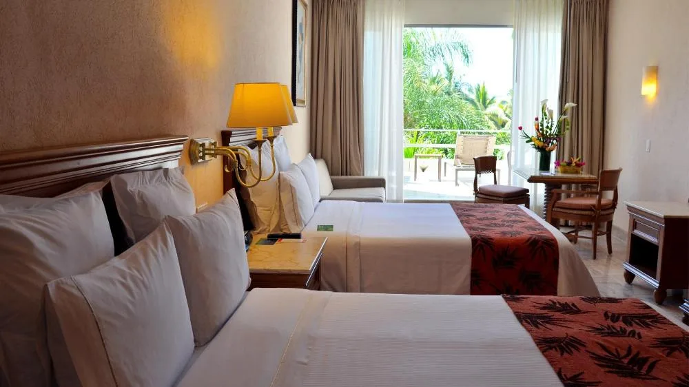 Family Room with two beds and balcony seating at Fiesta Americana Puerto Vallarta & Spa.