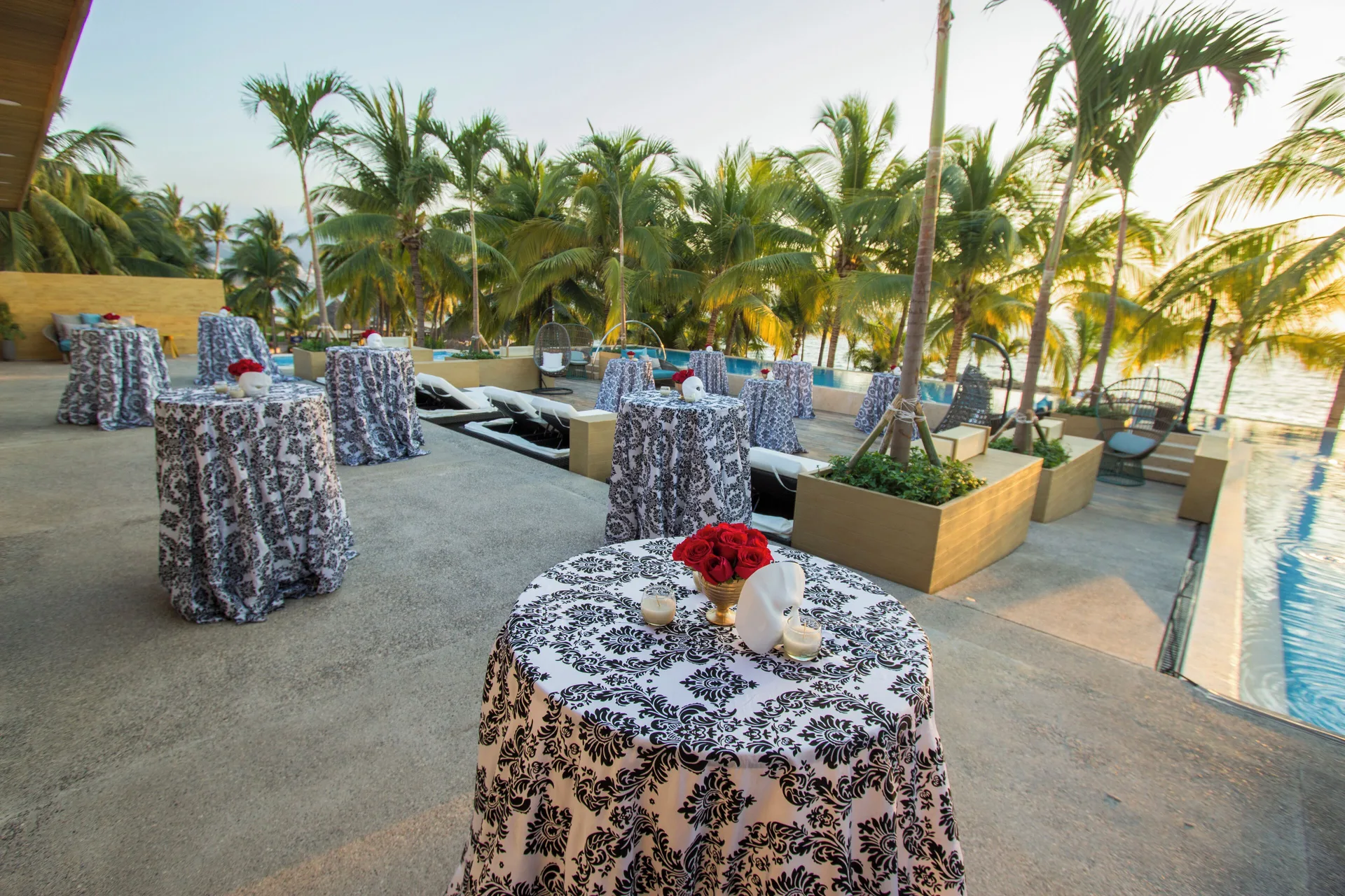 Outdoor cocktail tables beside the pool at Fiesta Americana Puerto Vallarta & Spa.