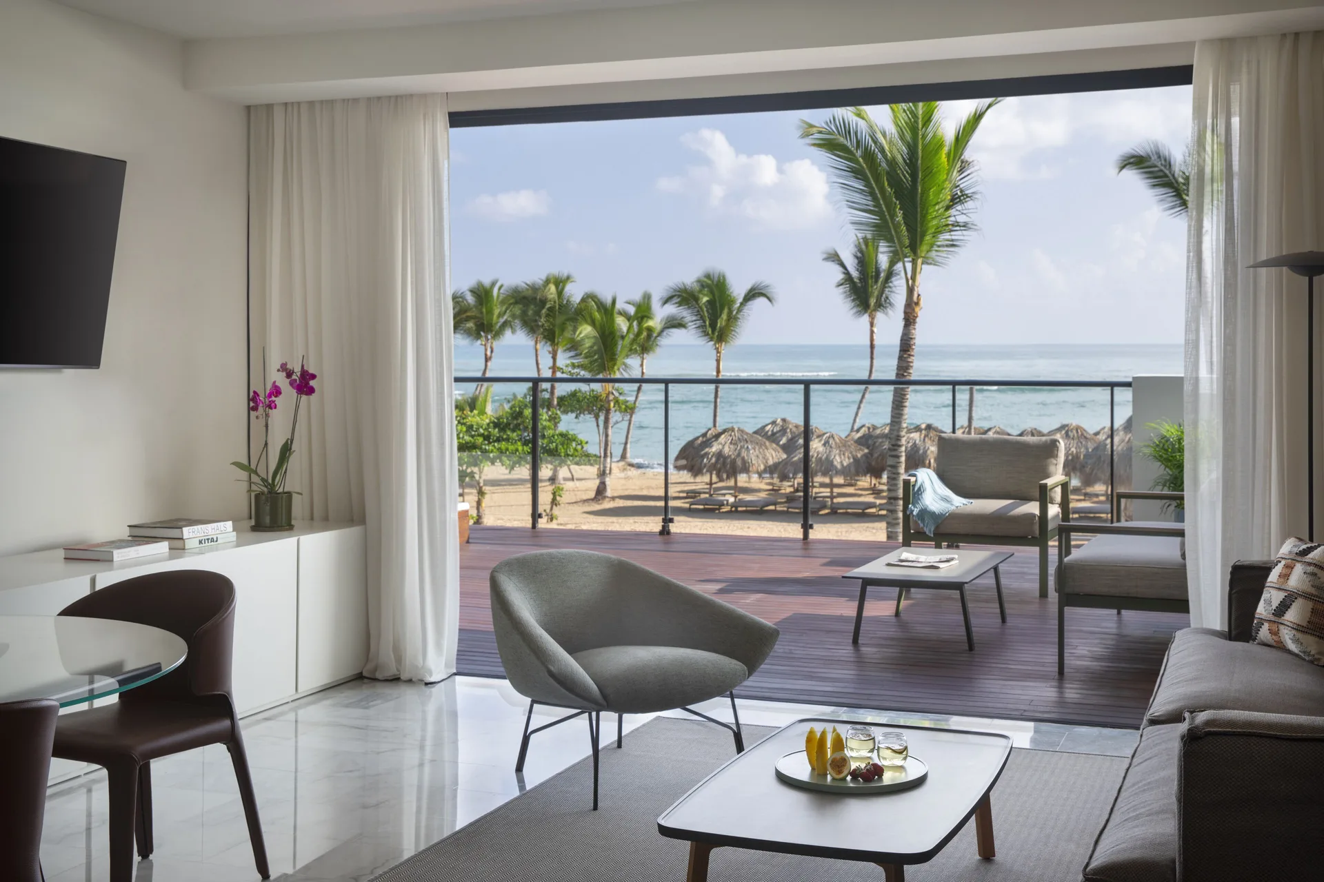 Suite sitting area with ocean-view terrace and palms at Finest Punta Cana.
