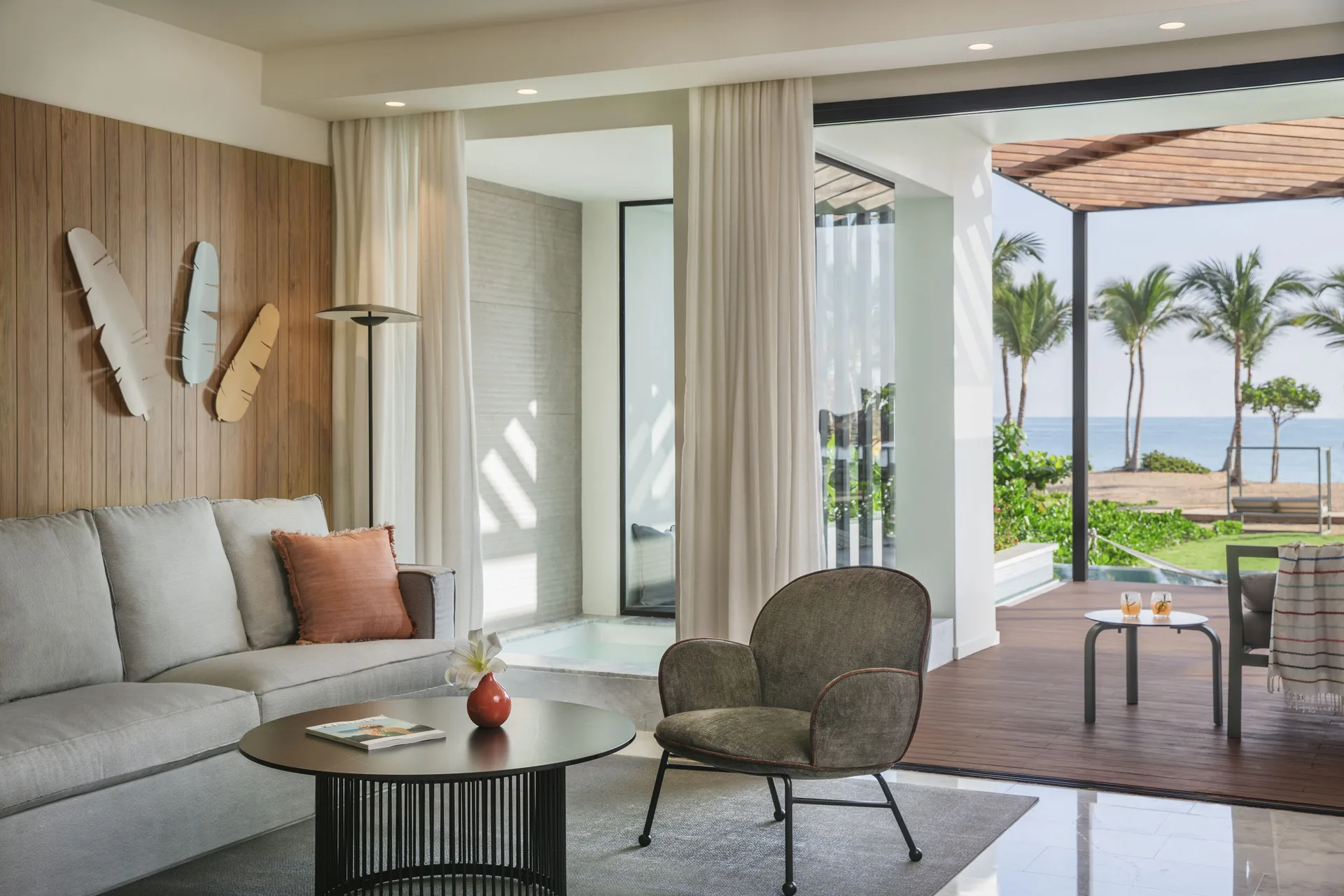 Oceanfront suite lounge with sofa, chair, and terrace at Finest Punta Cana.