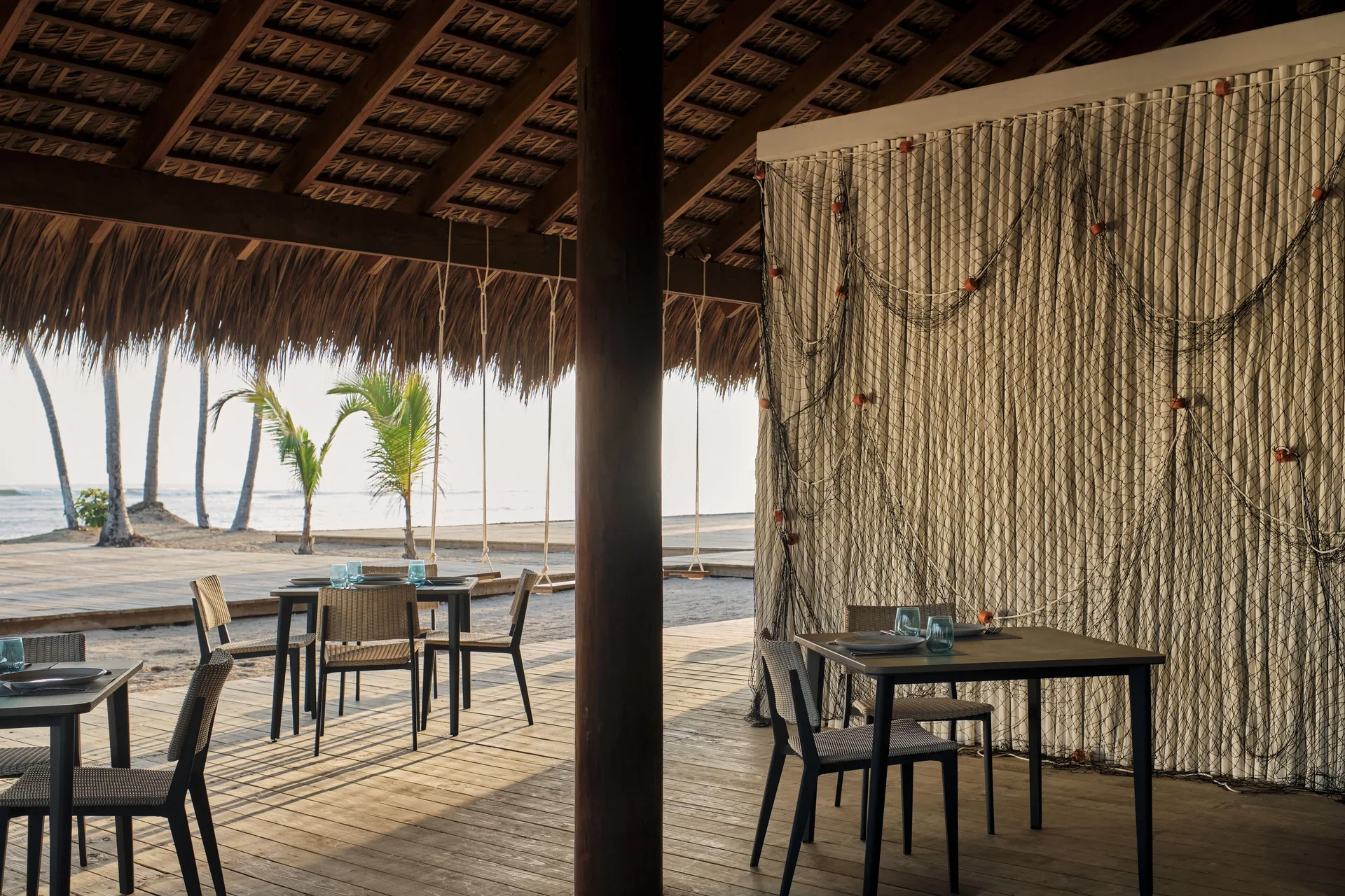 Beachfront open-air dining area with thatched roof at Finest Punta Cana.