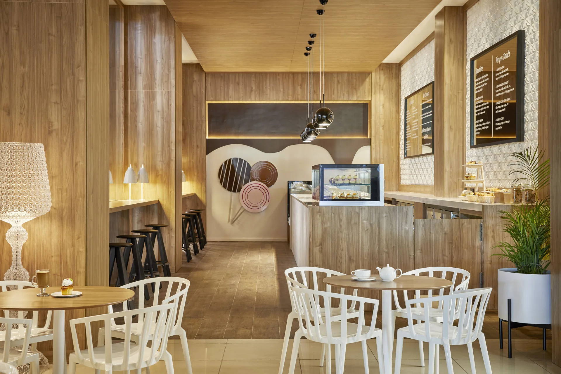 Bright dessert cafe with display cases and white seating at Finest Punta Cana.