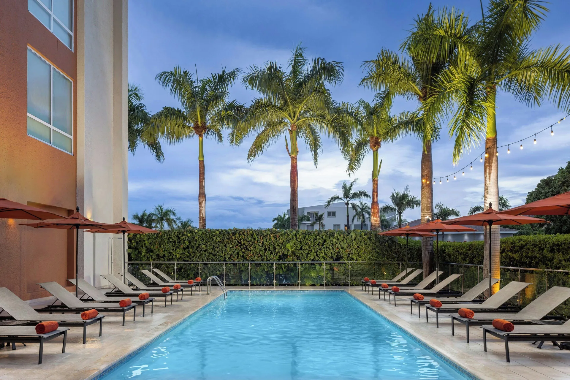 Evening pool view with palm trees and string lights at Four Points Puntacana Village.
