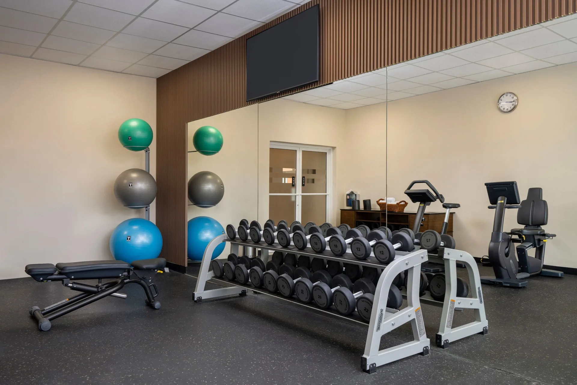 Fitness room with dumbbells and exercise balls at Four Points Puntacana Village.