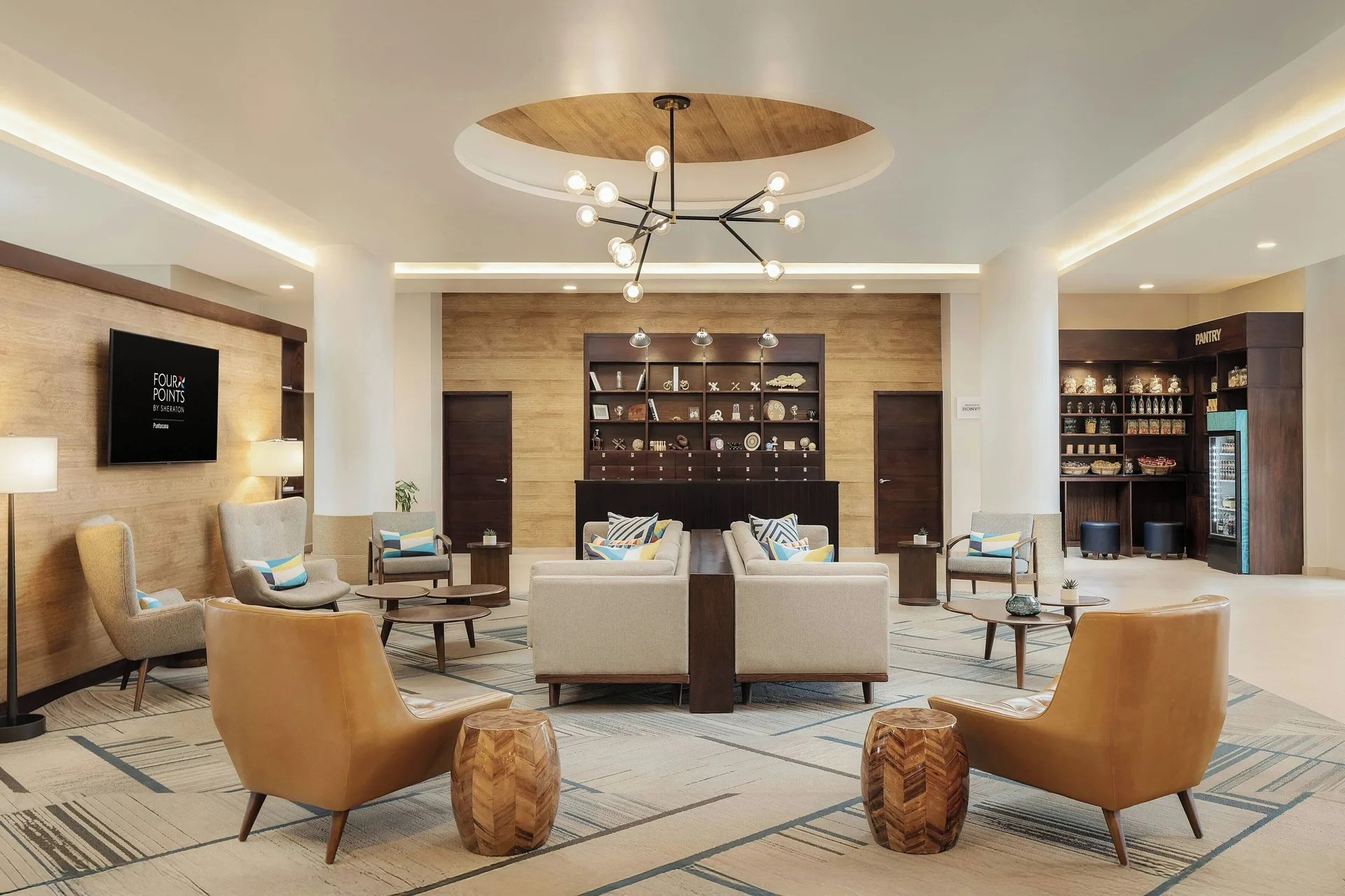 Lobby lounge with armchairs, sofas, and a pantry area at Four Points Puntacana Village.