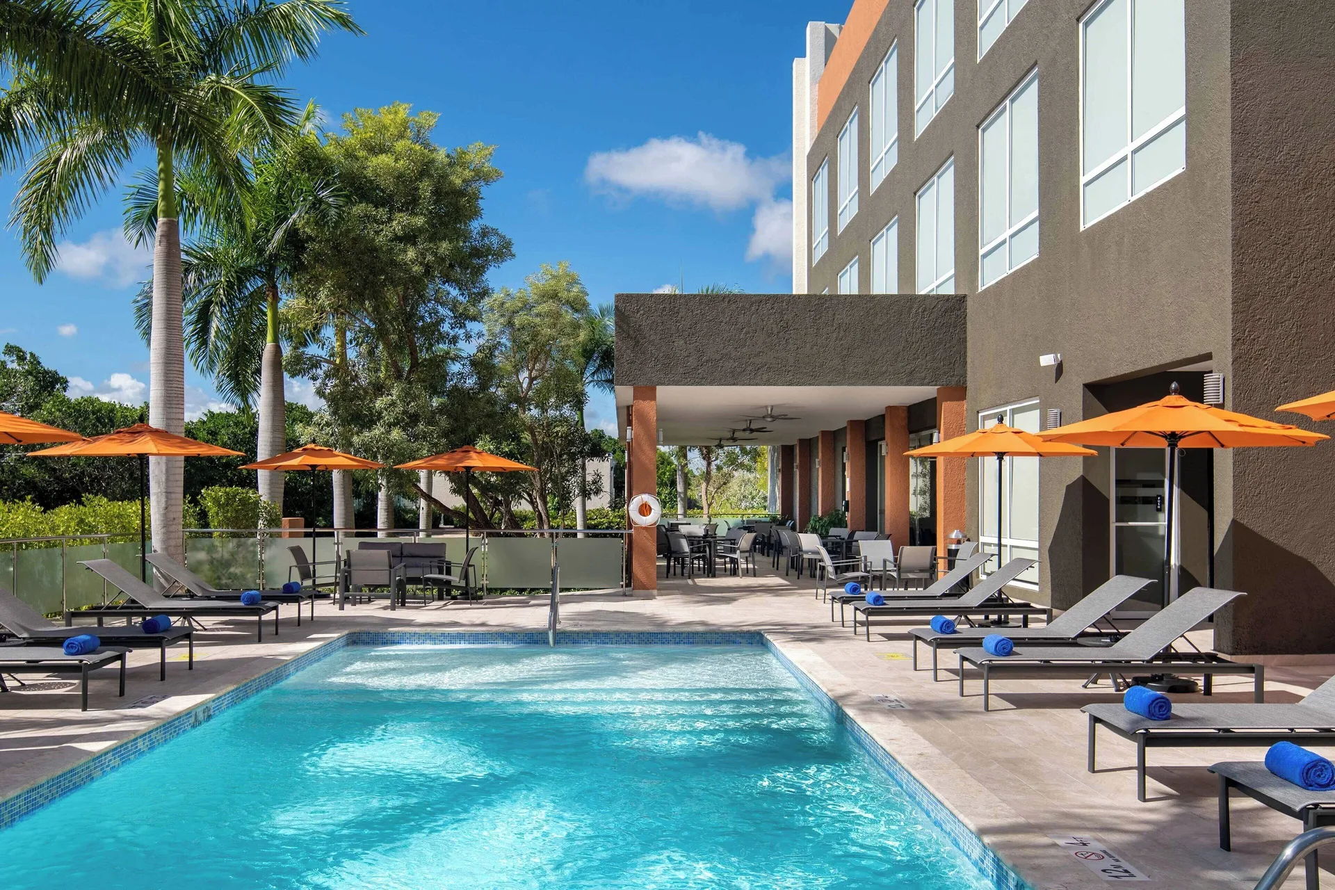 Pool deck with loungers, umbrellas, and covered terrace at Four Points Puntacana Village.