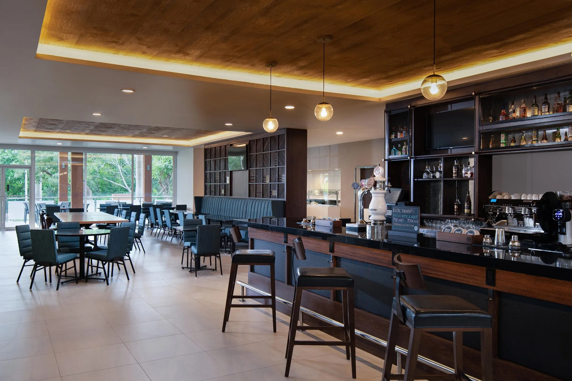 Bar and dining area with stools and lounge seating at Four Points Puntacana Village.