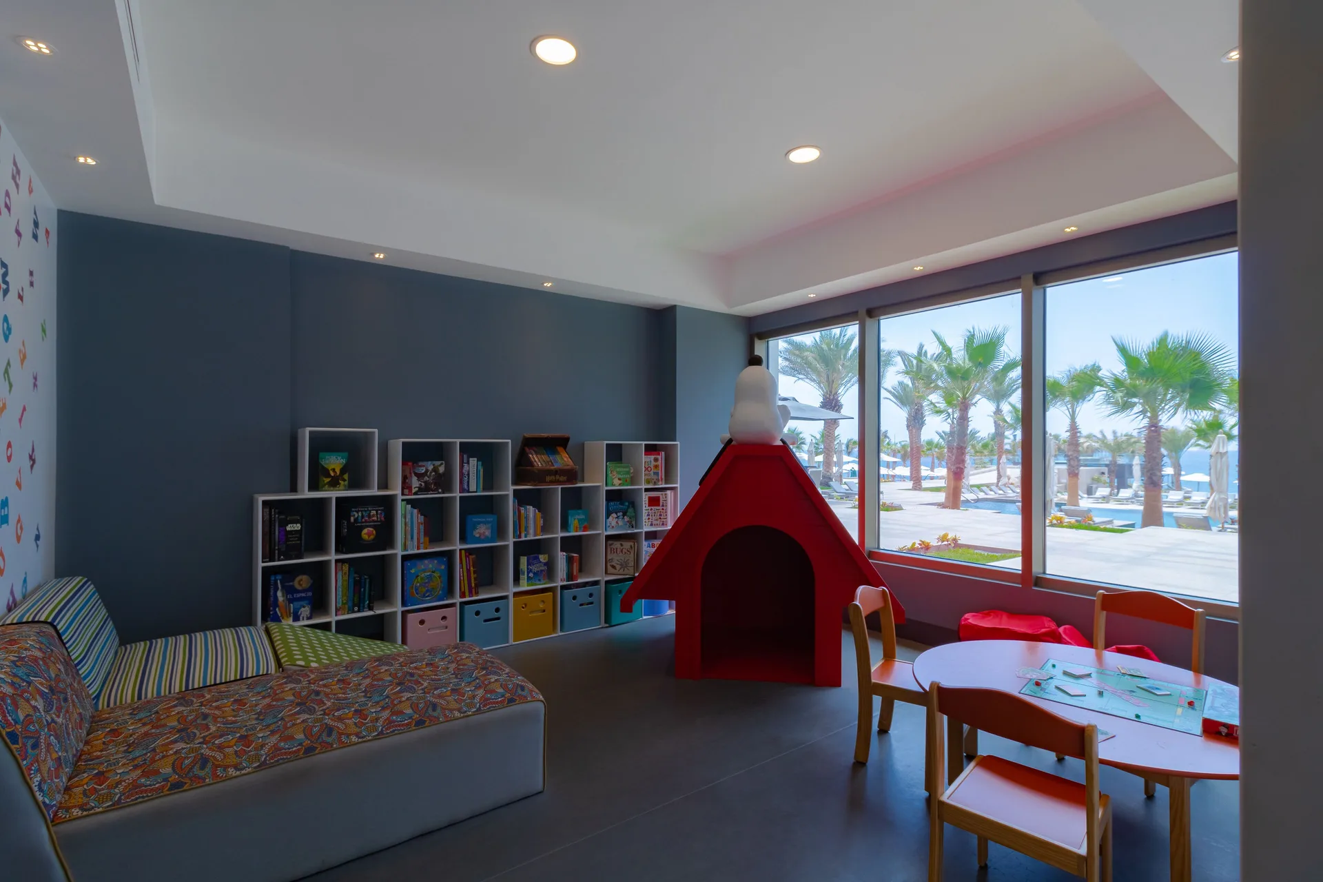 Children's playroom with bookshelves and poolside windows at Garza Blanca Los Cabos.