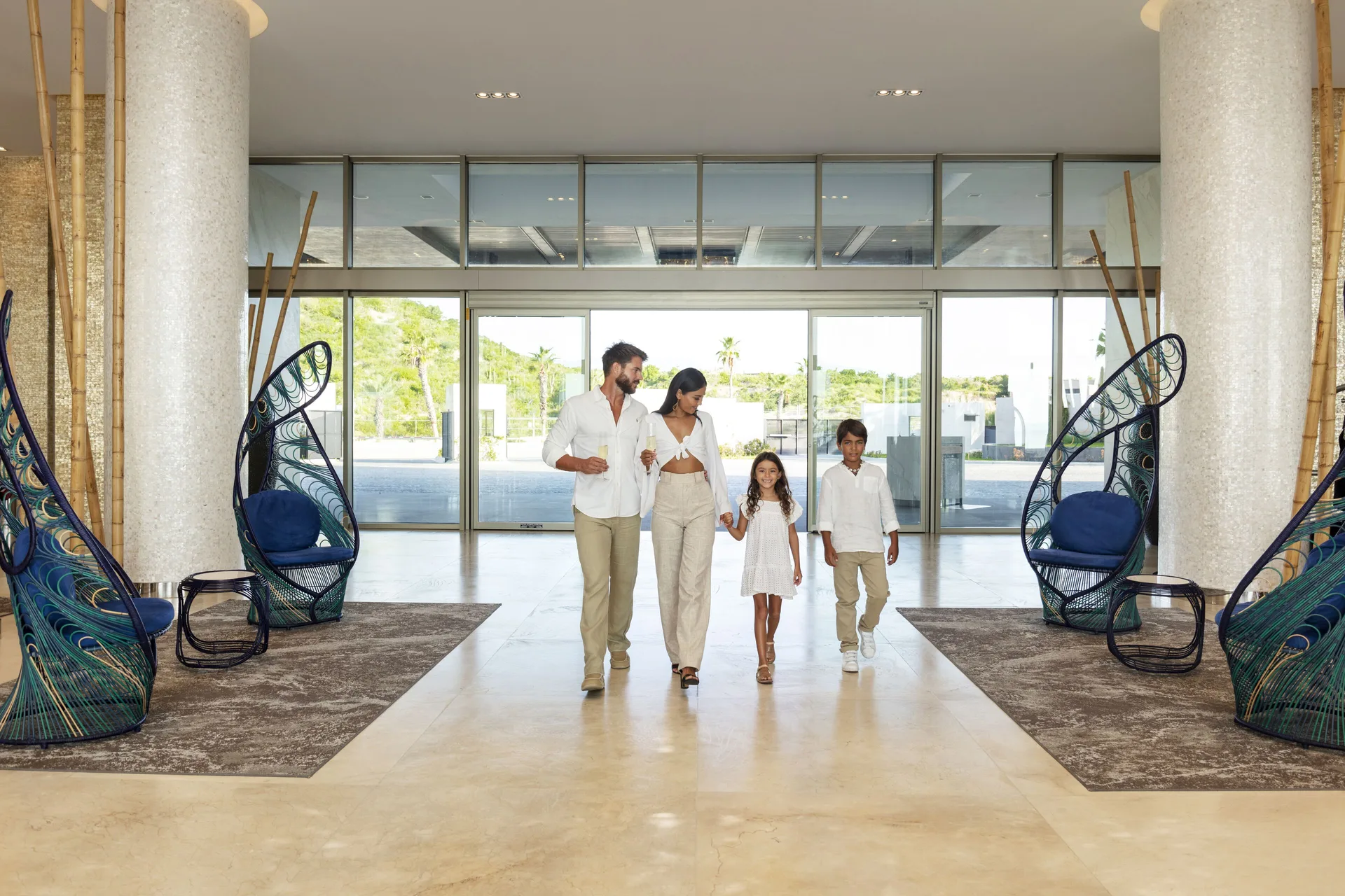 Family walking through the bright lobby entrance at Garza Blanca Los Cabos.