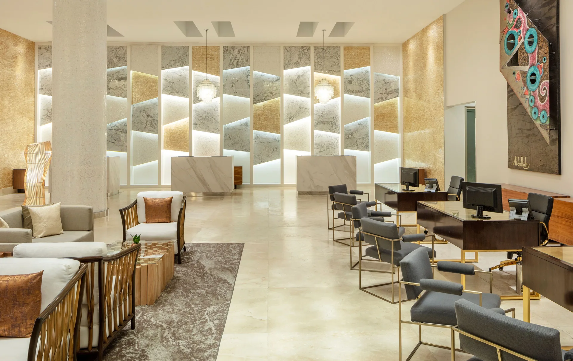 Lobby seating and concierge desks beside a feature wall at Garza Blanca Los Cabos.