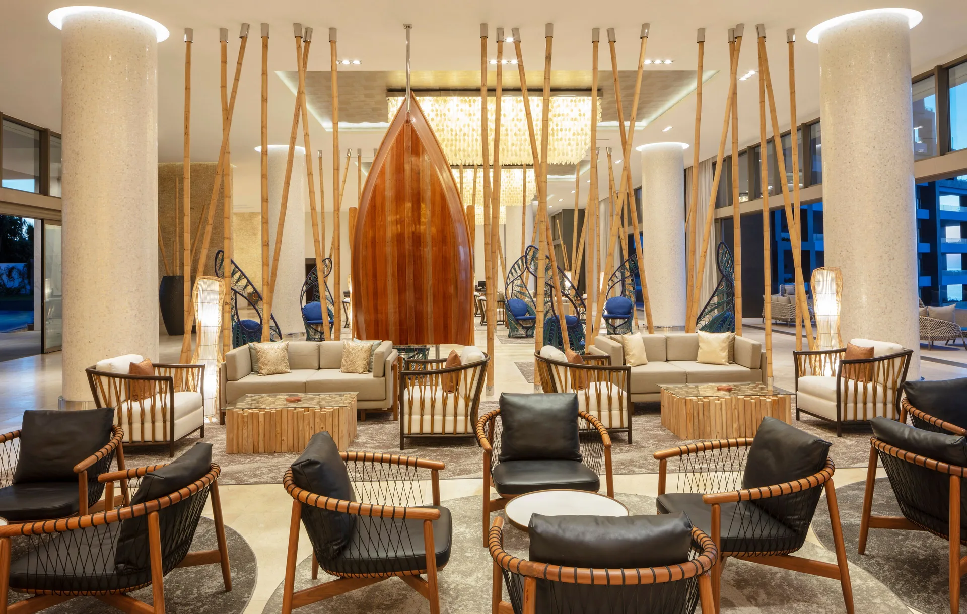 Lobby seating with a wooden boat sculpture at Garza Blanca Los Cabos.