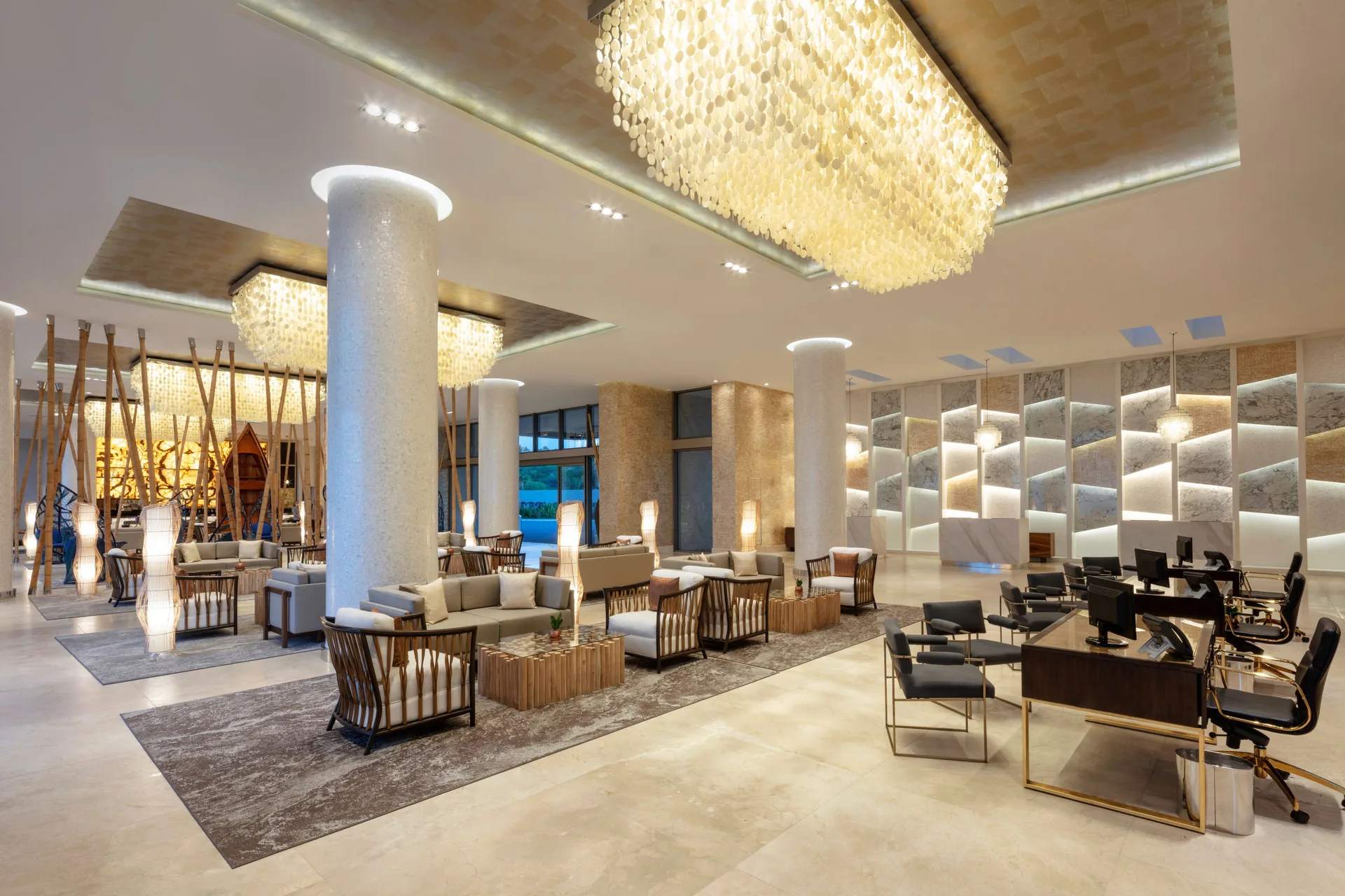 Lobby seating and front desk area with chandeliers at Garza Blanca Los Cabos.