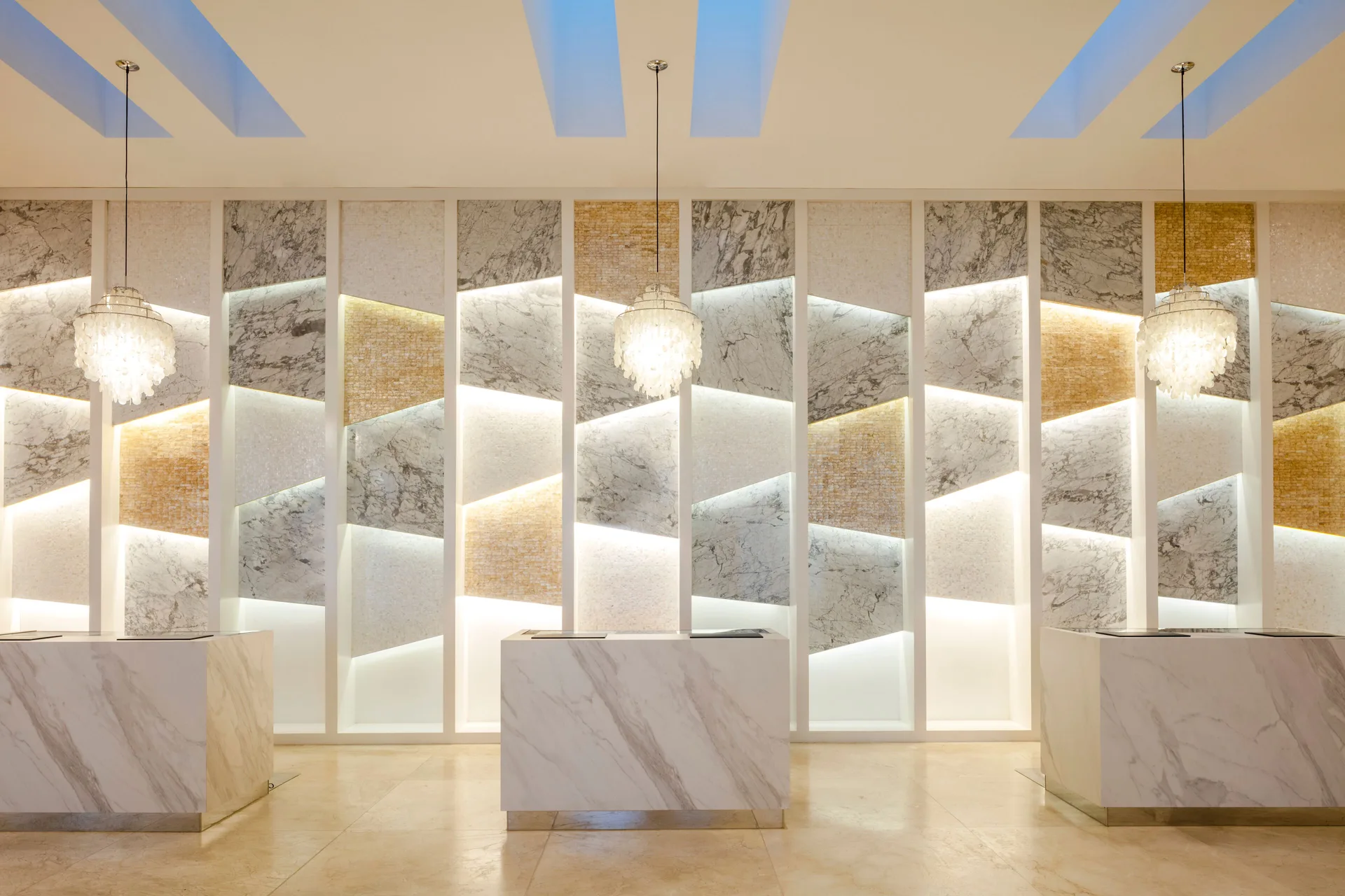 Marble reception desks against a backlit feature wall at Garza Blanca Los Cabos.