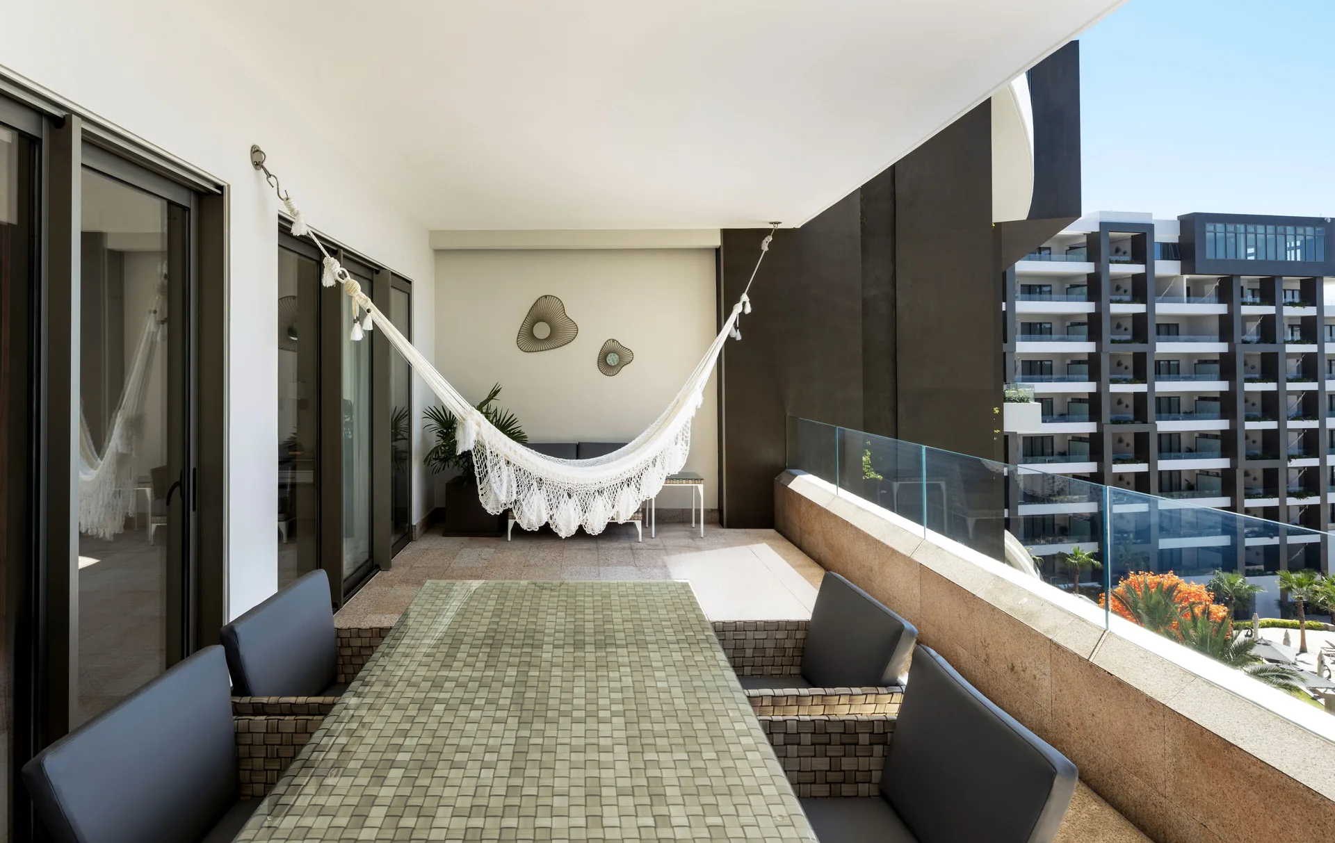 1 Bedroom Suite balcony with hammock and outdoor dining table at Garza Blanca Los Cabos.