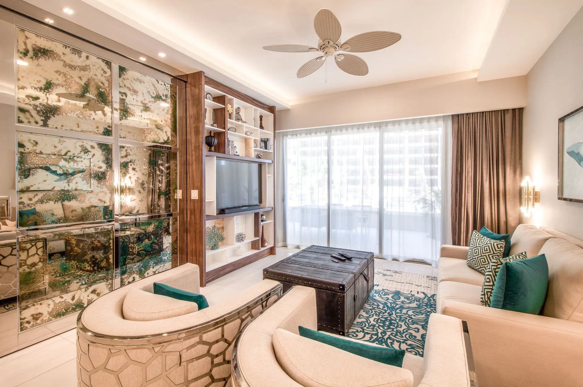 1 Bedroom Suite living room with sofas, TV wall, and balcony doors at Garza Blanca Los Cabos.