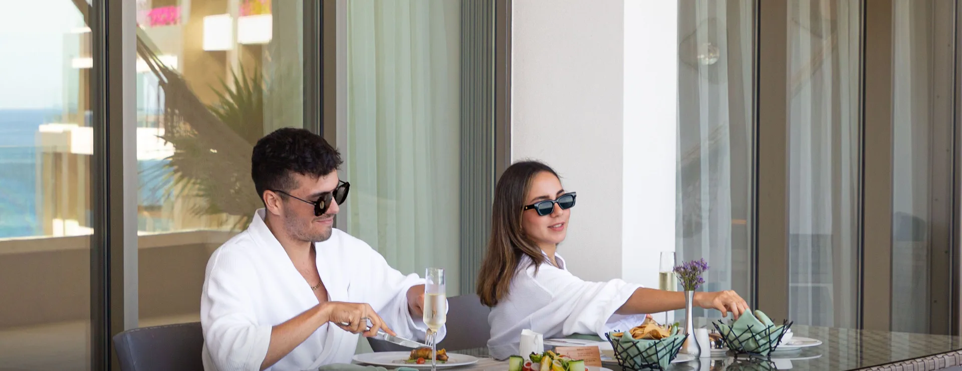 Guests dining on a One Bedroom Suite balcony at Garza Blanca Los Cabos.