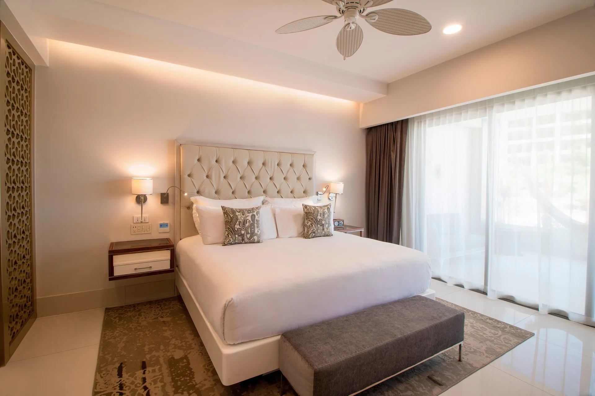 One Bedroom Suite king bed beside balcony curtains at Garza Blanca Los Cabos.
