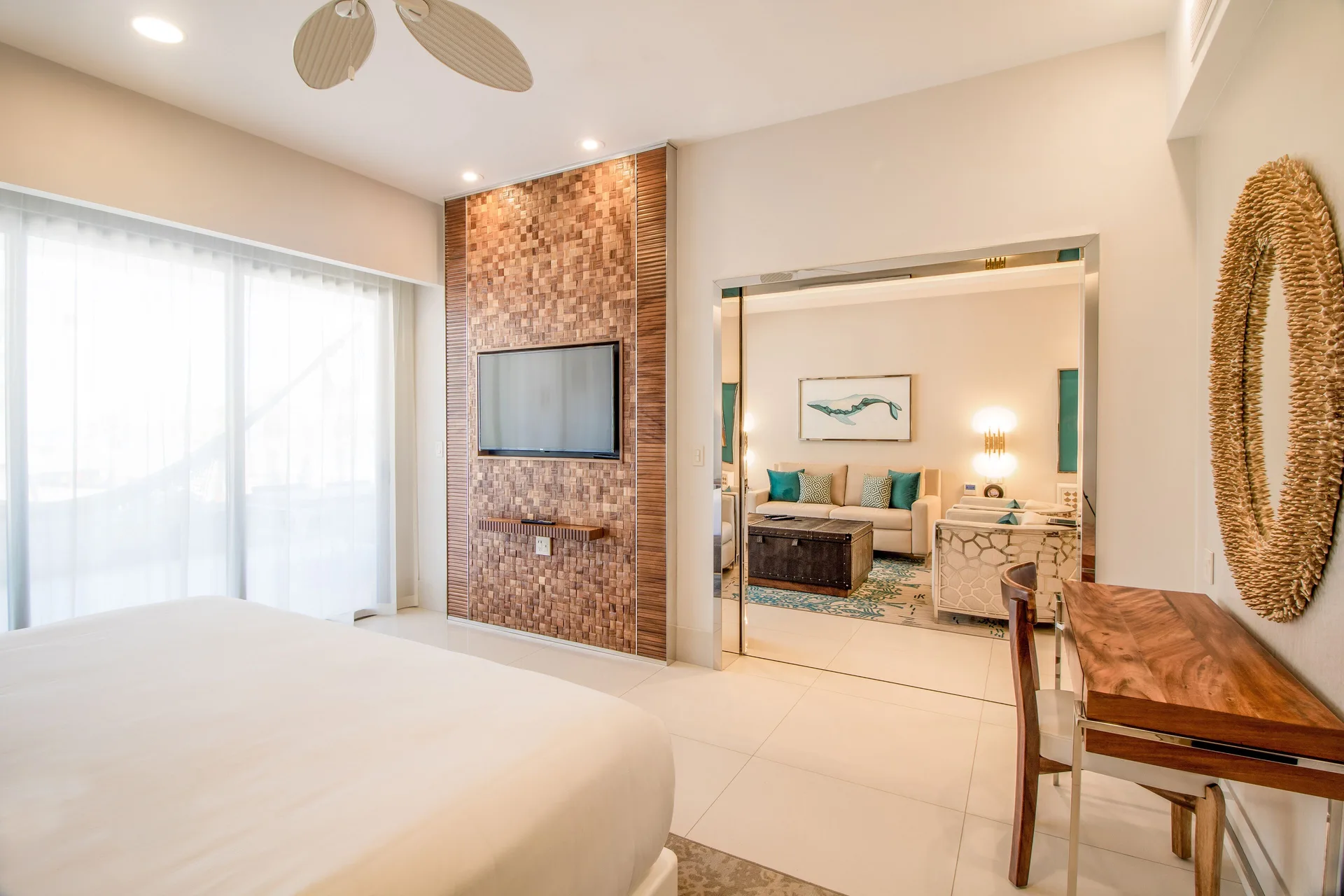 One Bedroom Suite bedroom with wall TV and living room beyond at Garza Blanca Los Cabos.