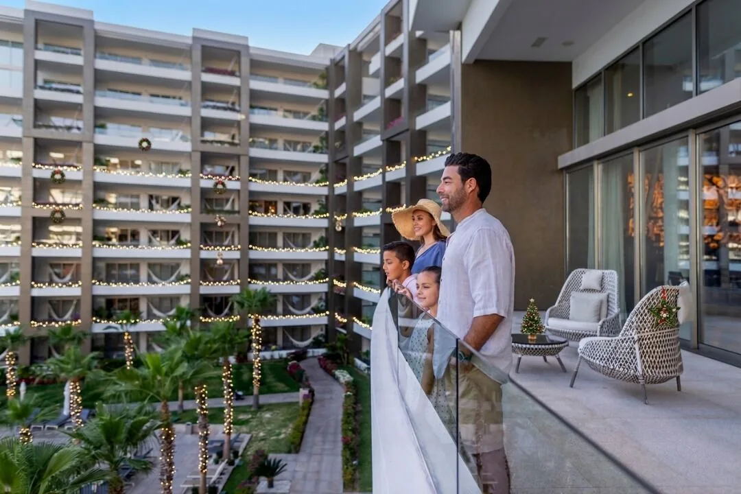 Family on the balcony of a 2 Bedroom Suite at Garza Blanca Los Cabos overlooking the courtyard.