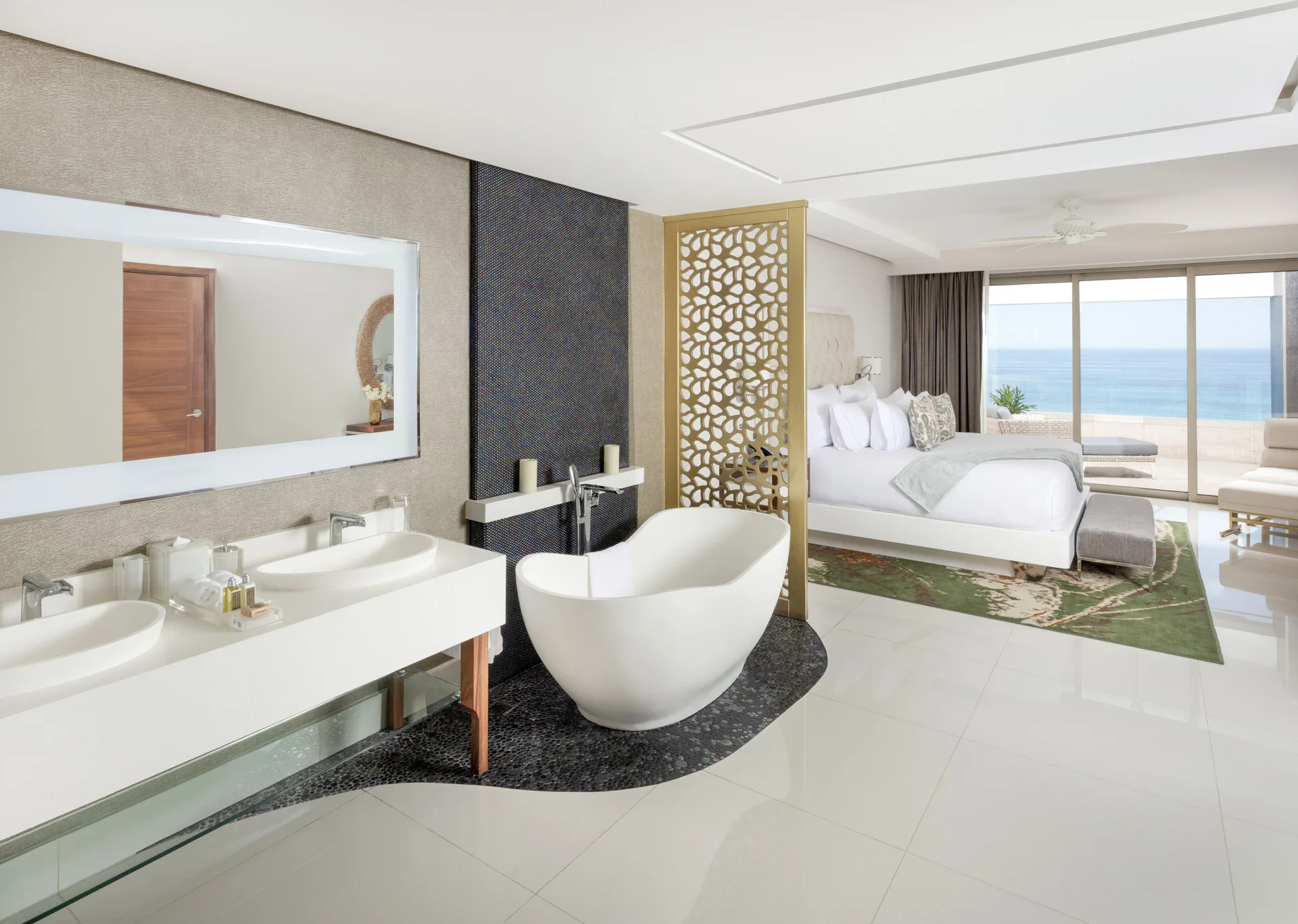 Ocean-view bedroom with open bath and soaking tub at Garza Blanca Los Cabos.