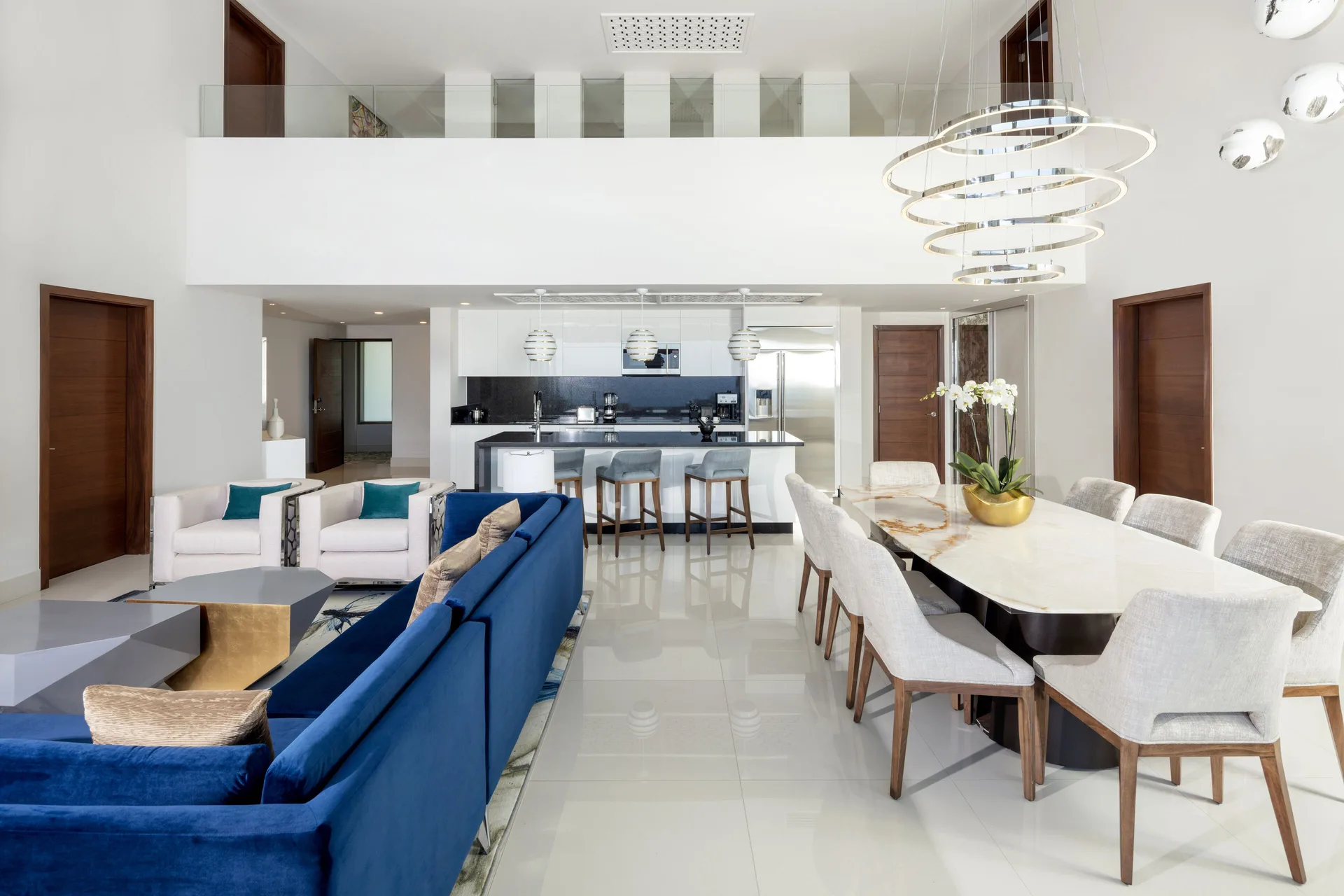 Loft living room with dining table, kitchen, and upper level at Garza Blanca Los Cabos.