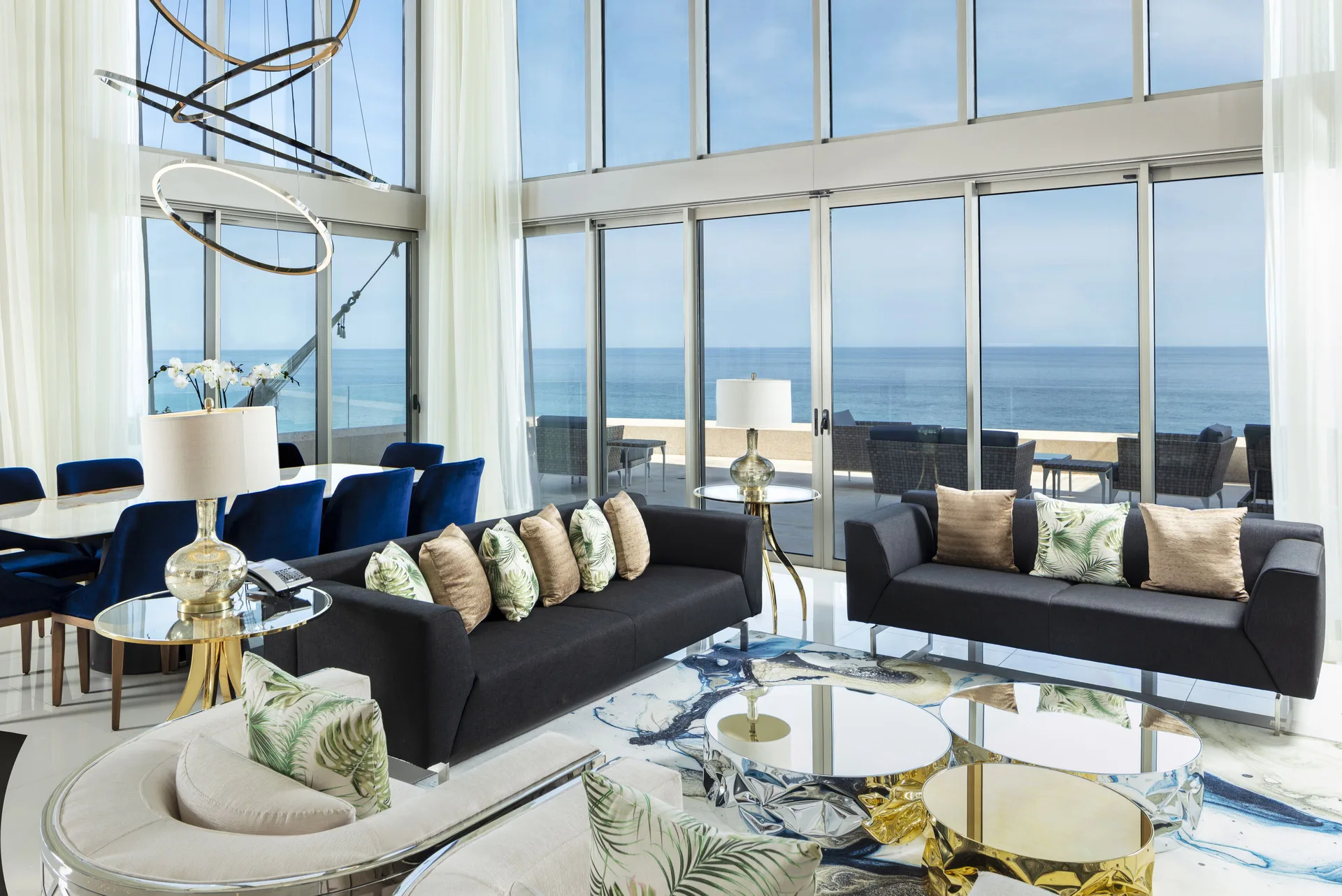 Penthouse lounge with sofas and ocean-view glass doors at Garza Blanca Los Cabos.