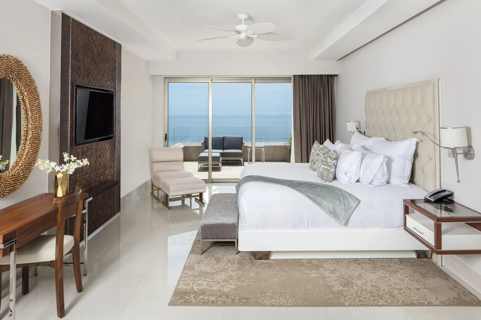 Oceanfront penthouse bedroom with king bed at Garza Blanca Los Cabos facing a balcony and sea view.