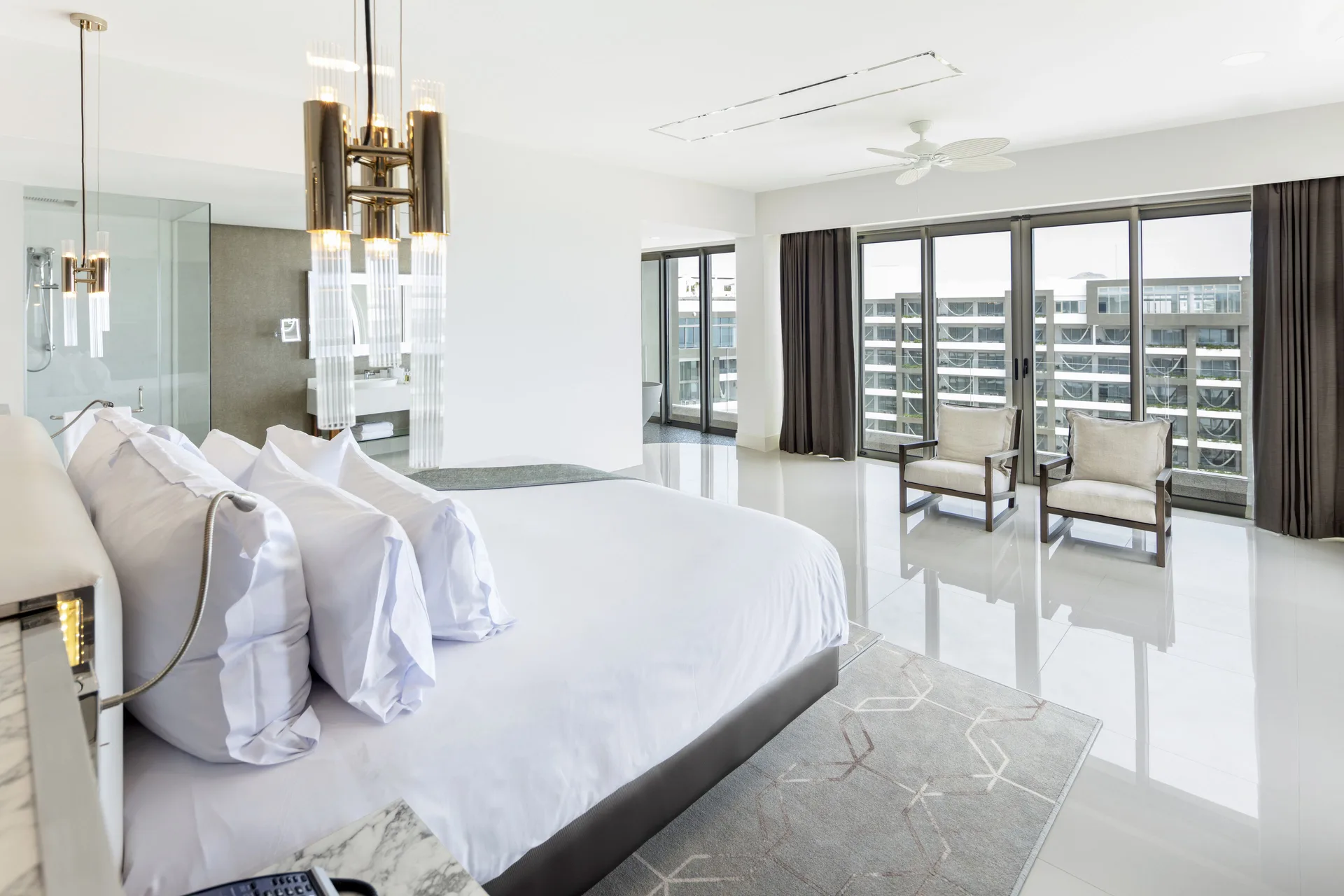 Penthouse bedroom with king bed and floor-to-ceiling windows at Garza Blanca Los Cabos.