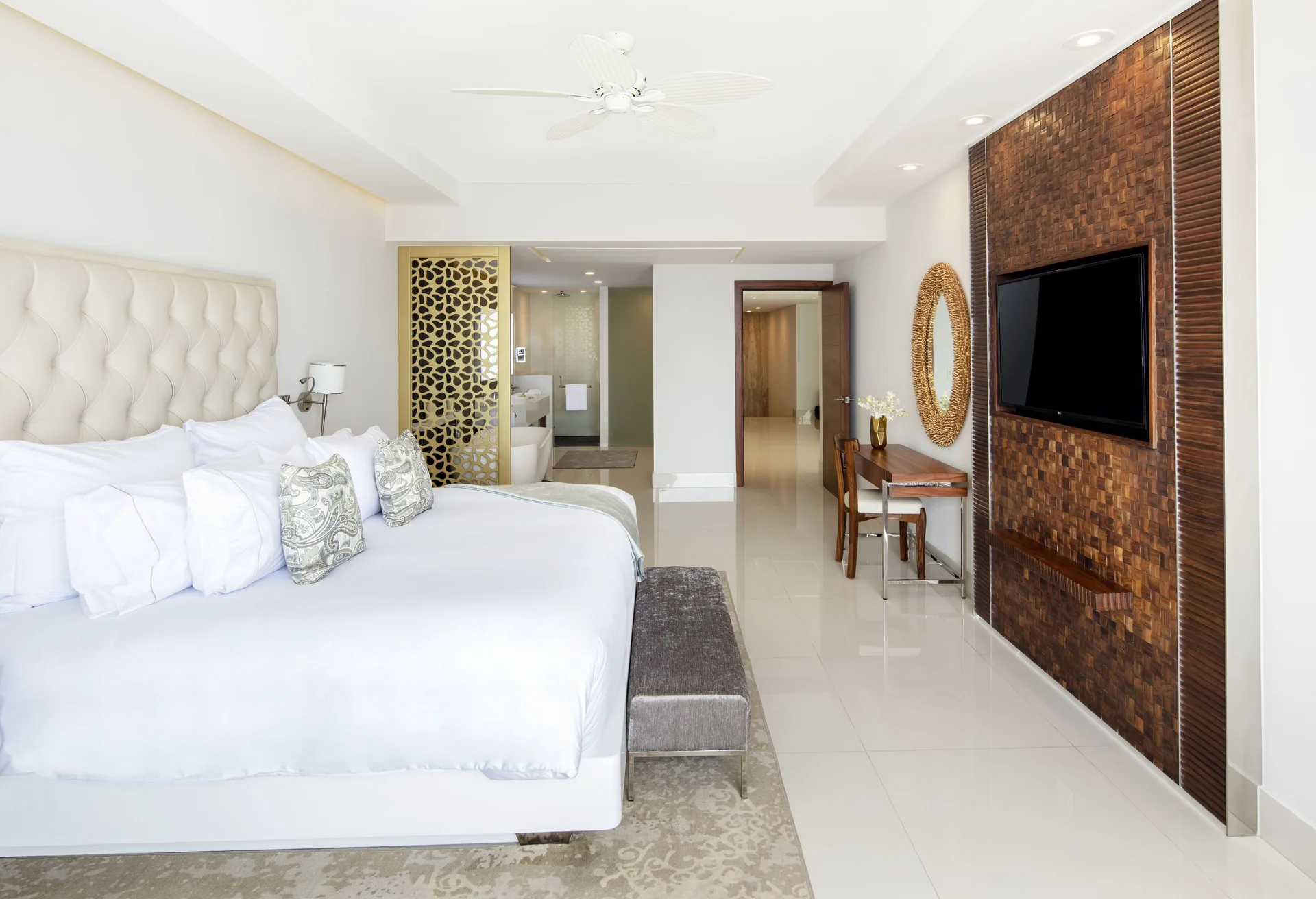 Oceanfront penthouse bedroom with king bed, TV wall, and desk at Garza Blanca Los Cabos.