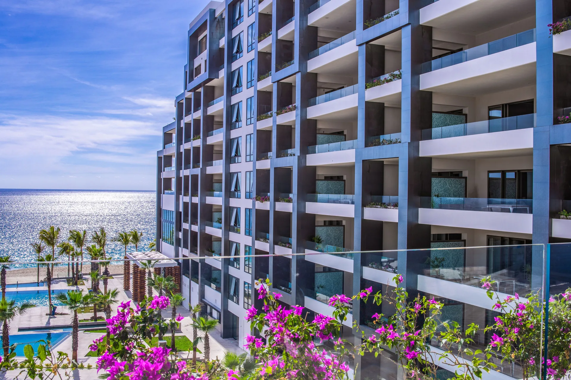 Junior Suite Ocean View balcony perspective of resort building and ocean at Garza Blanca Los Cabos.