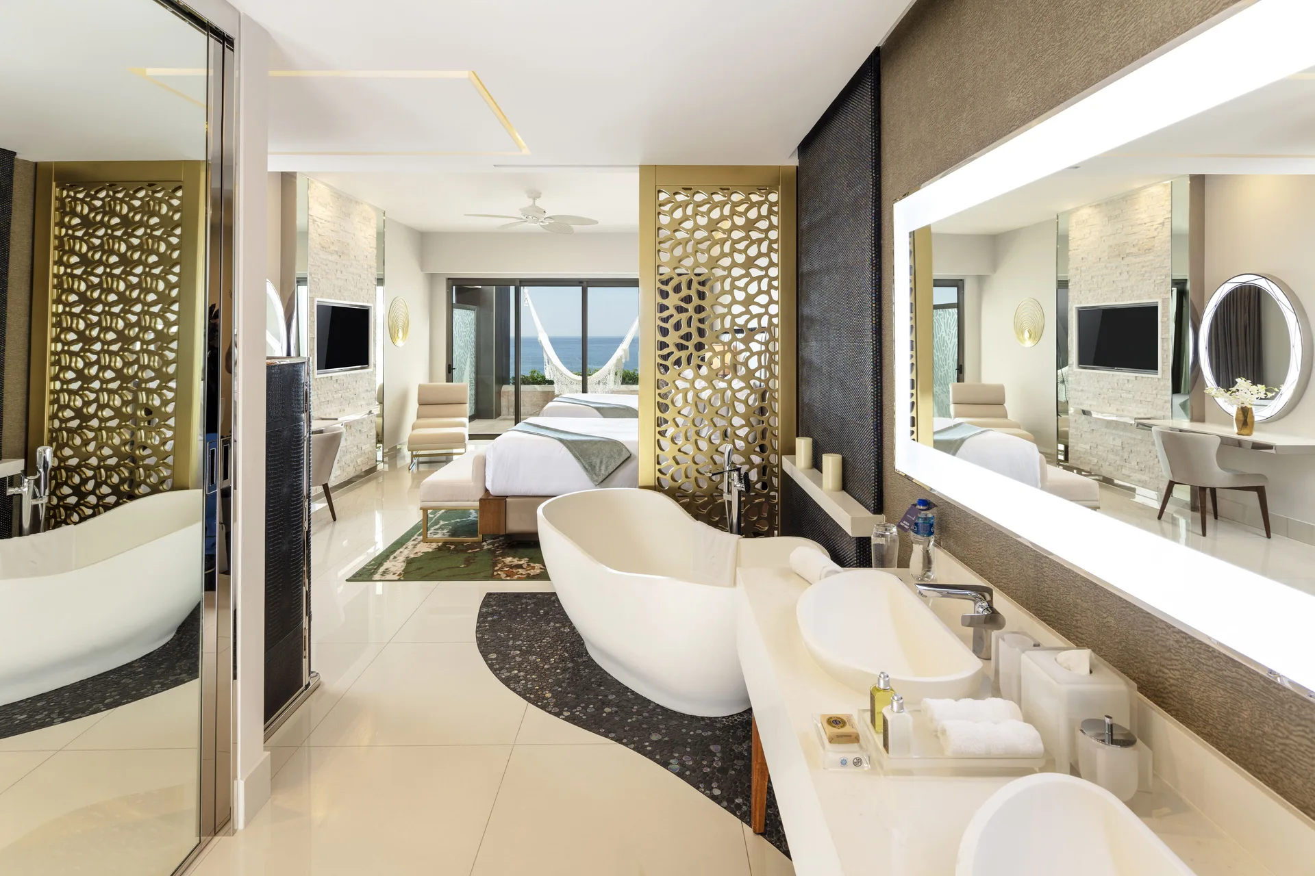 Junior Suite Ocean View bathroom with tub, vanity, and bedroom beyond at Garza Blanca Los Cabos.