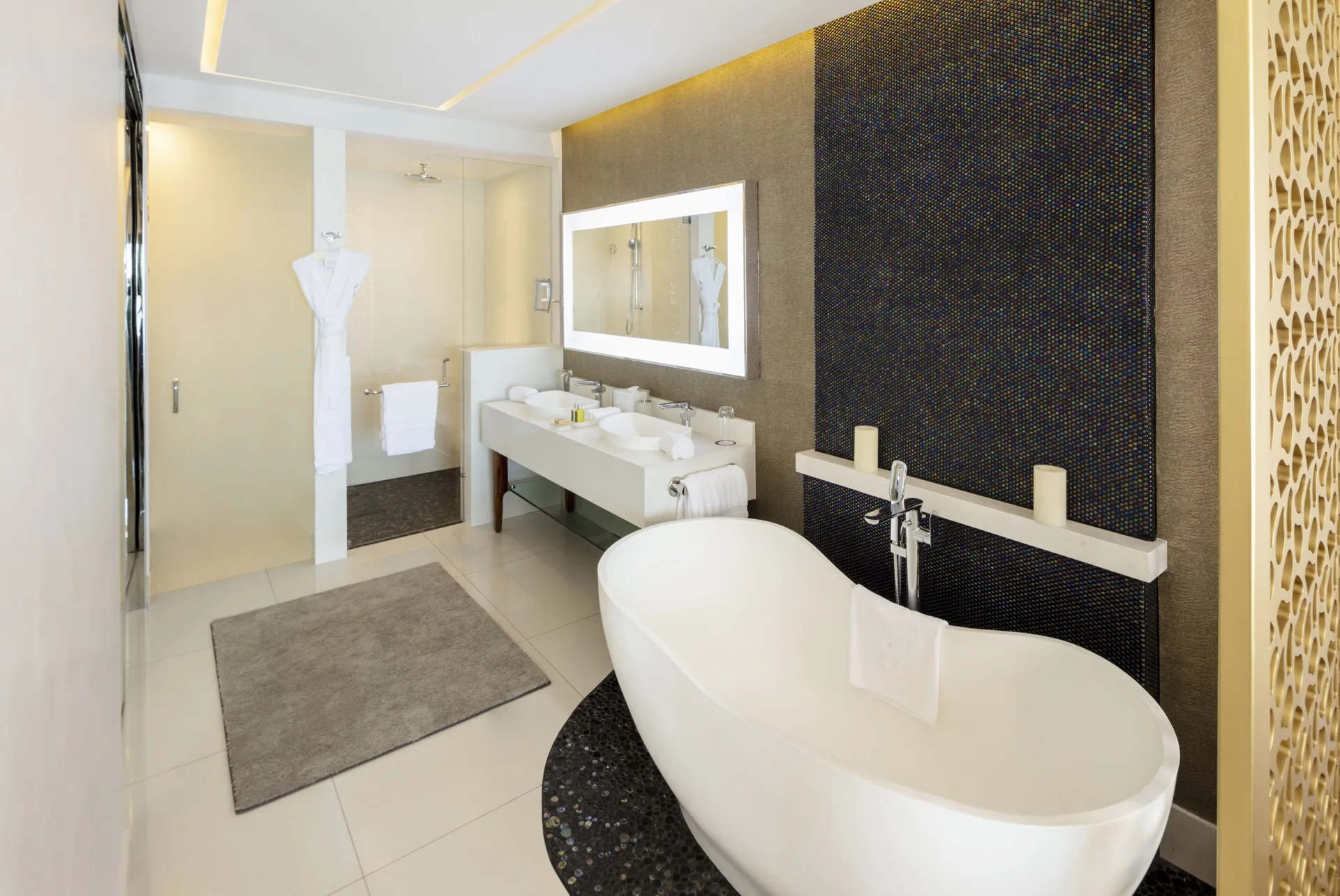 Junior Suite bathroom with oval tub, vanity, and shower at Garza Blanca Los Cabos.