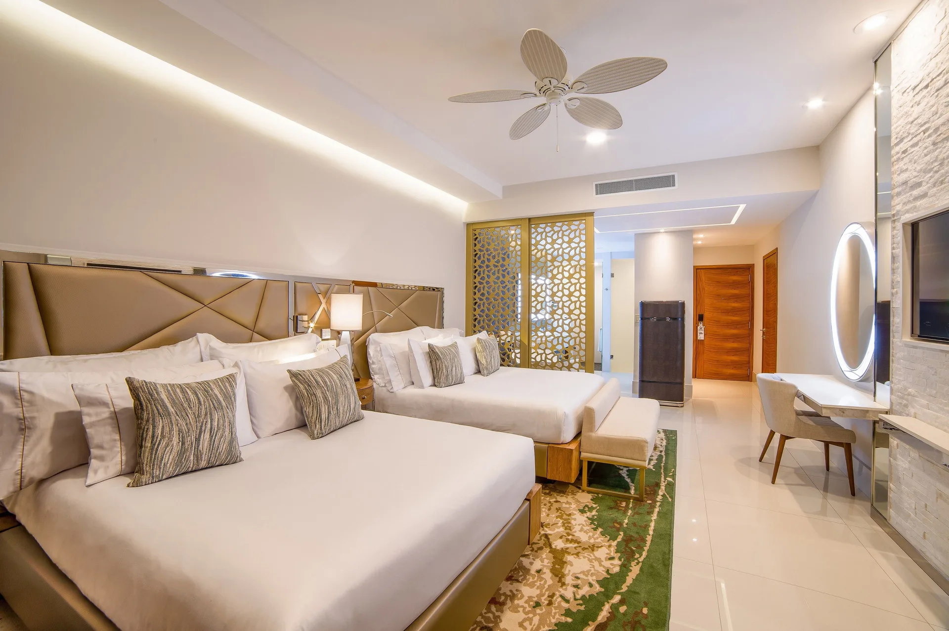 Junior Suite with two queen beds, entry area, and lit vanity mirror at Garza Blanca Los Cabos.