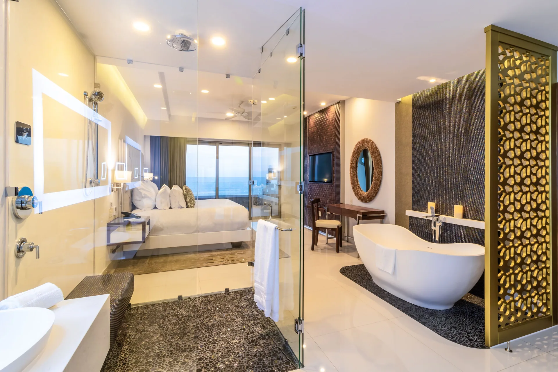 Loft Ocean View glass shower, soaking tub, and bedroom at Garza Blanca Los Cabos.