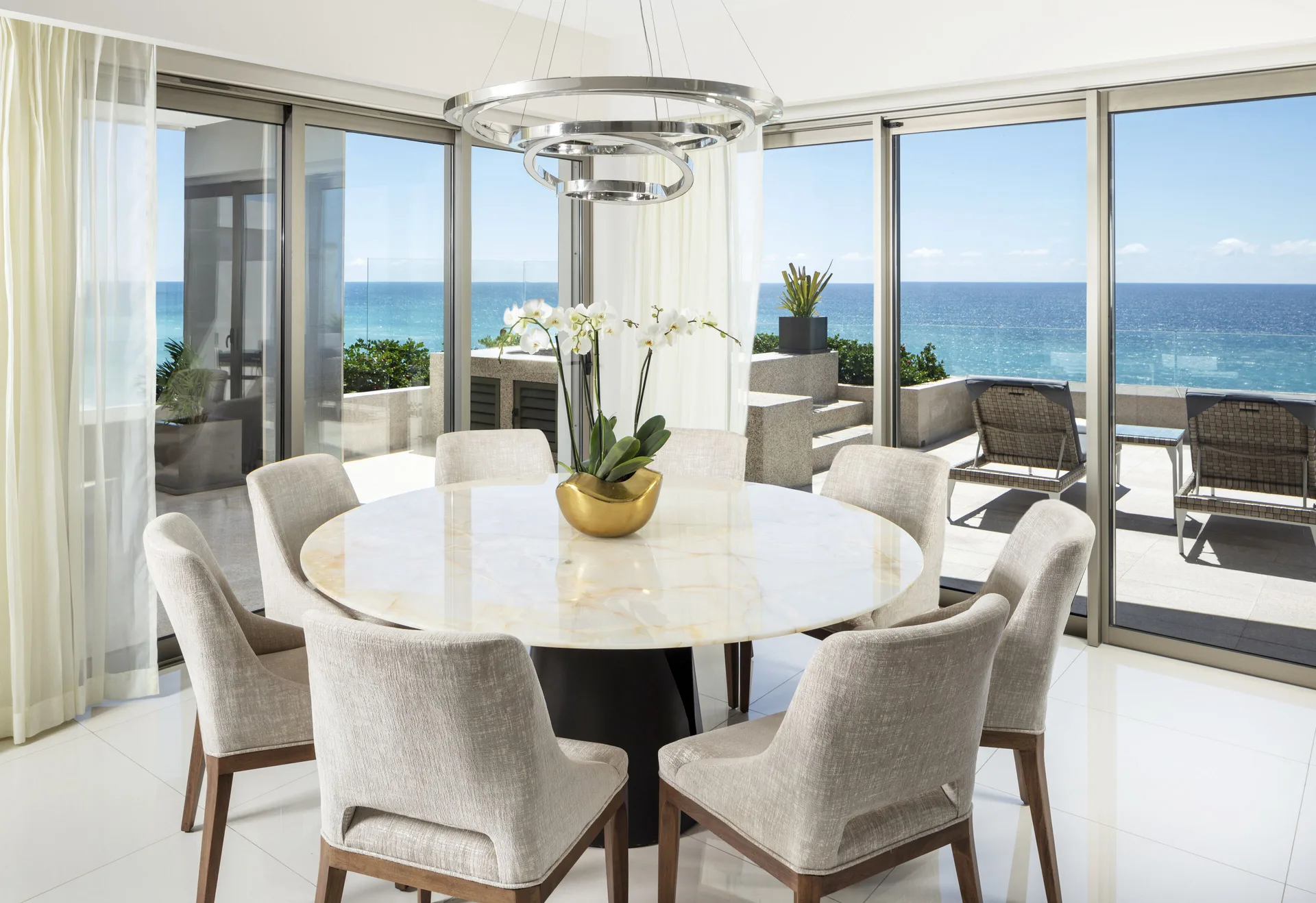 Round dining table beside ocean-view windows at Garza Blanca Los Cabos.