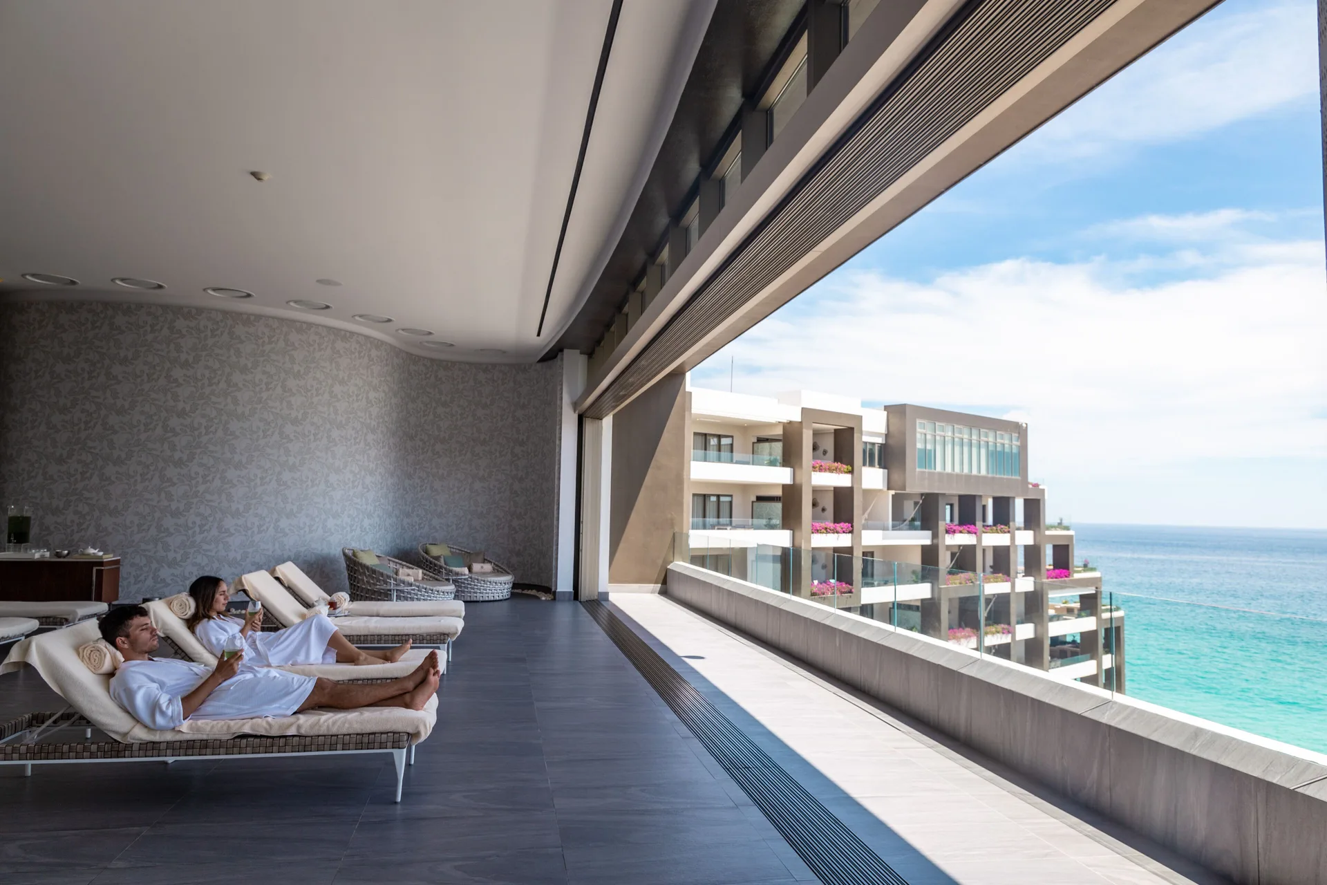 Covered ocean-view terrace with lounge chairs at Garza Blanca Los Cabos.