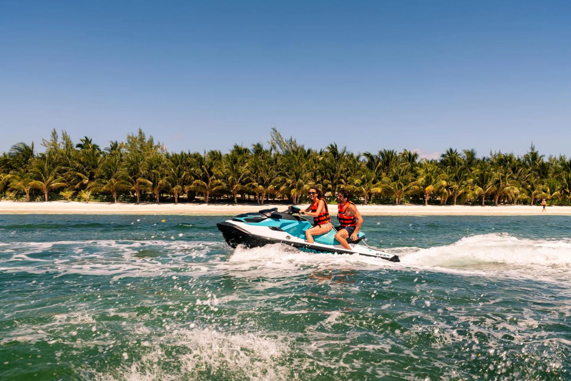 Two riders on a personal watercraft off the beach at Generations Riviera Maya.