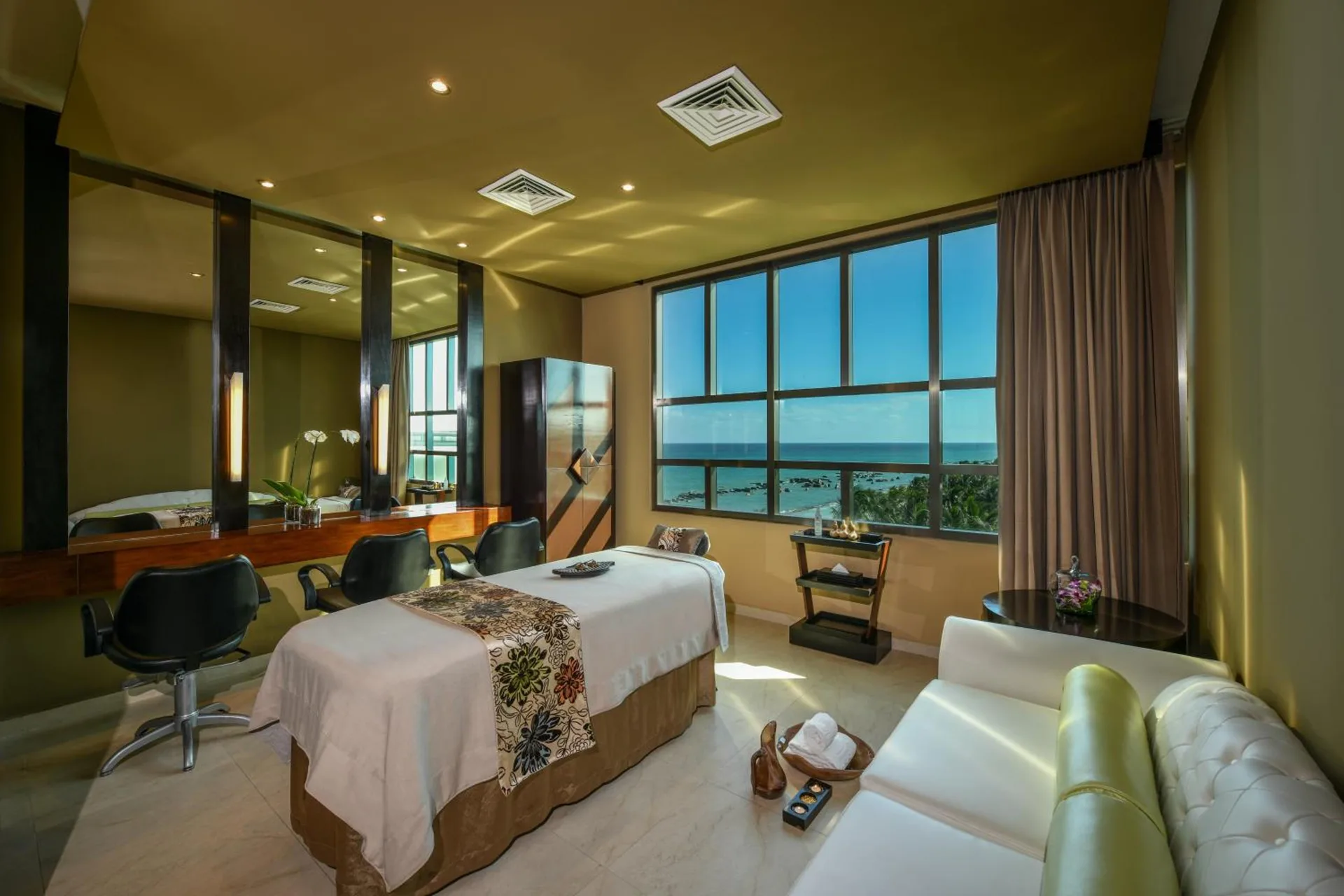 Spa treatment room with massage table and ocean-facing windows at Generations Riviera Maya.