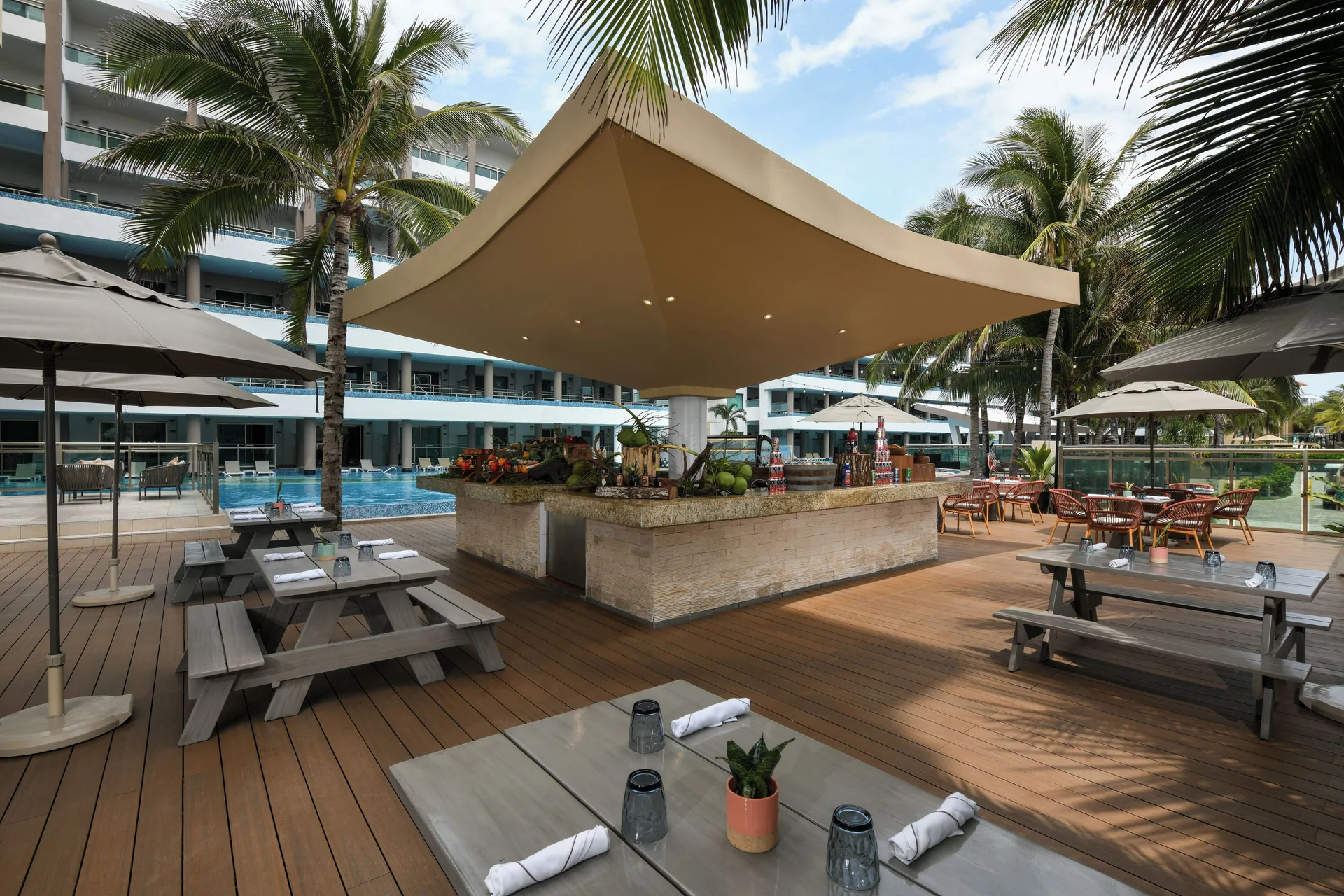 Poolside deck with shaded bar and picnic tables at Generations Riviera Maya.