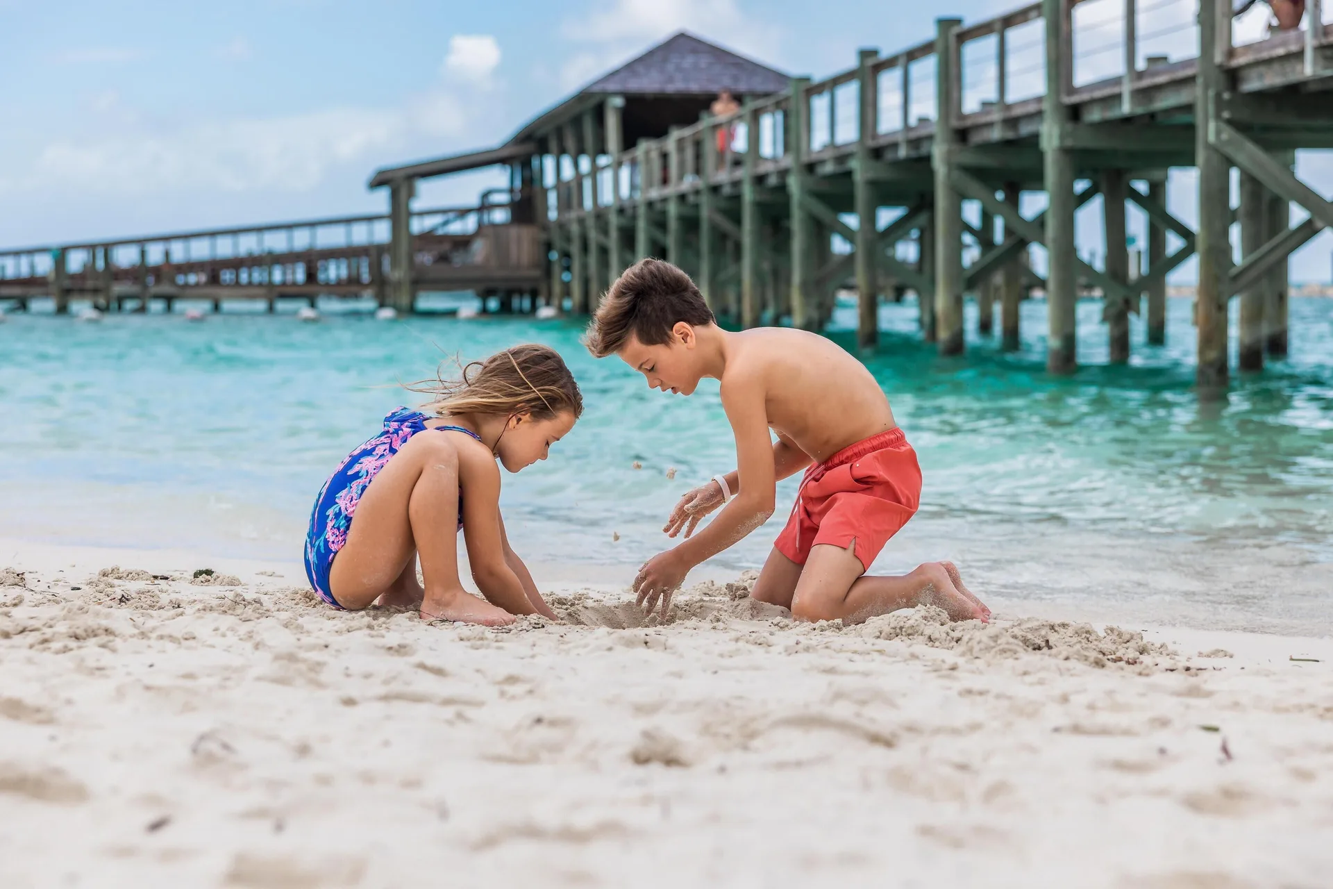 Children playing in the sand by the pier at Grand Hyatt Baha Mar.