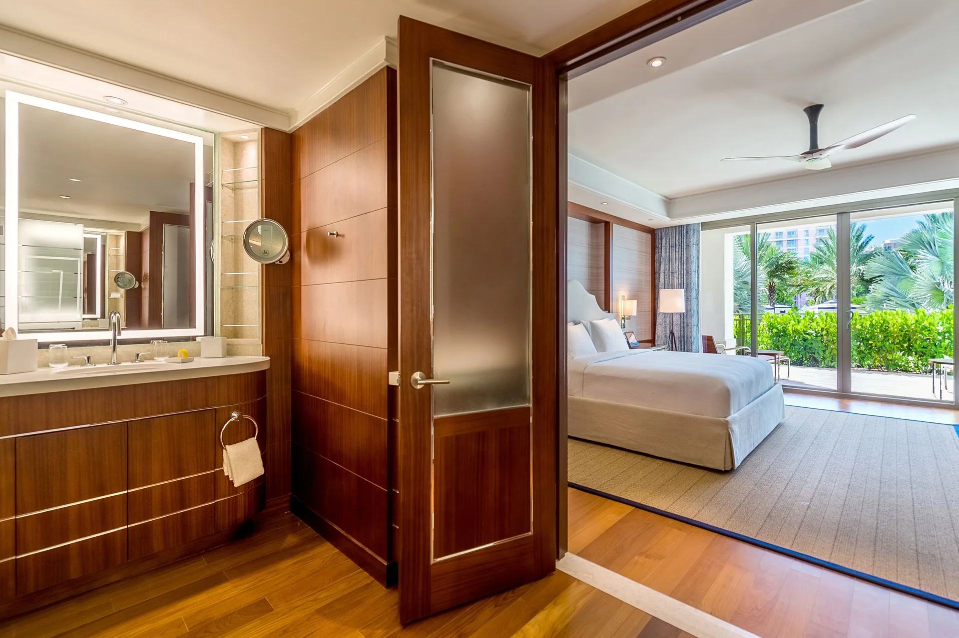 Guest room bathroom vanity opening to a king bed and patio at Grand Hyatt Baha Mar.