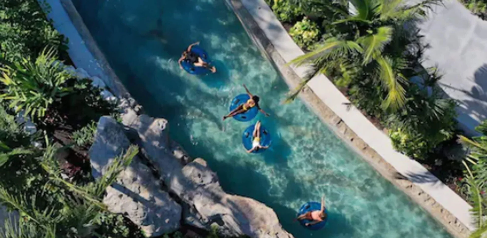 Guests float in blue tubes along a tropical lazy river at Grand Hyatt Baha Mar.