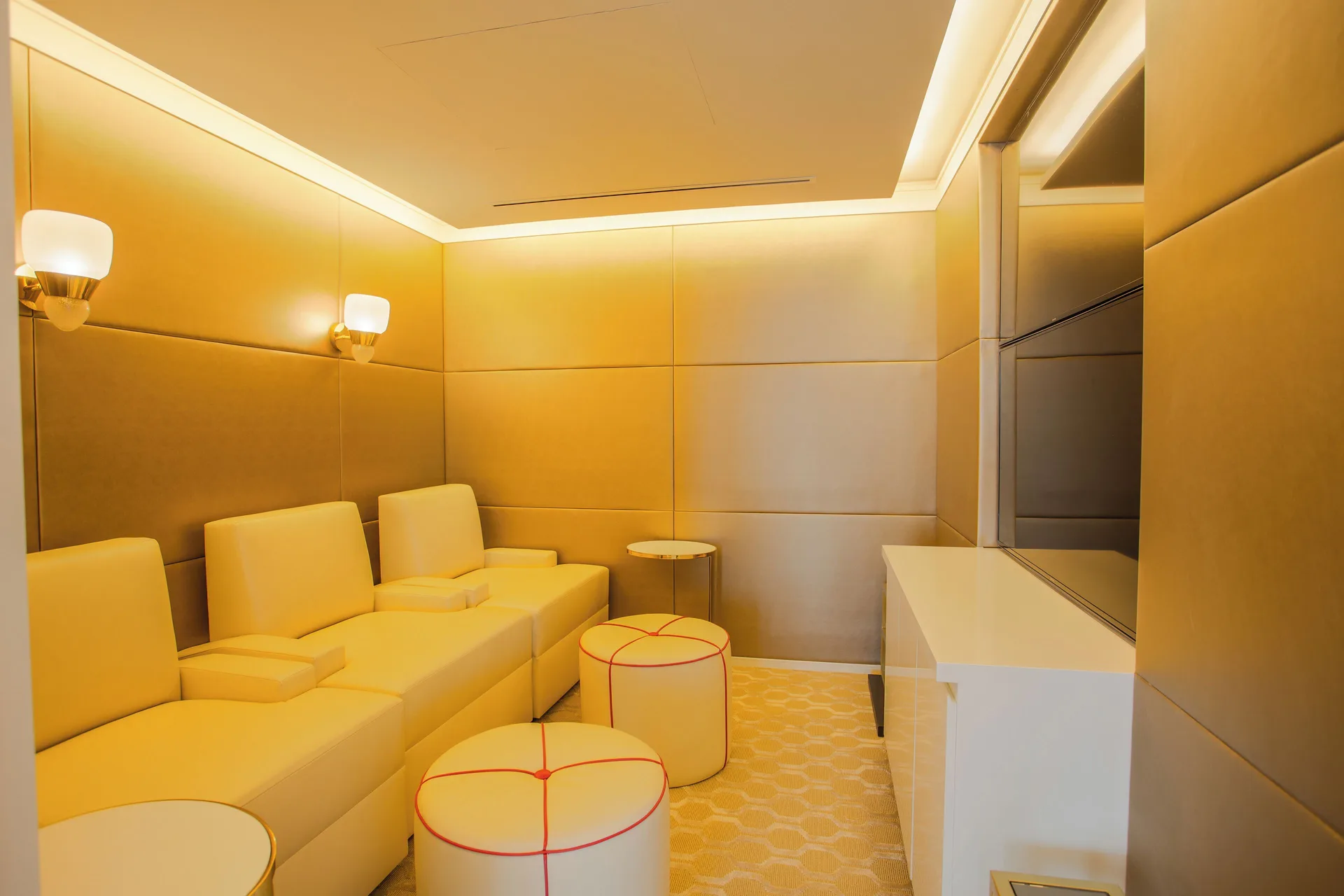 Private lounge with cream seating and wall-mounted TV at Grand Hyatt Baha Mar.