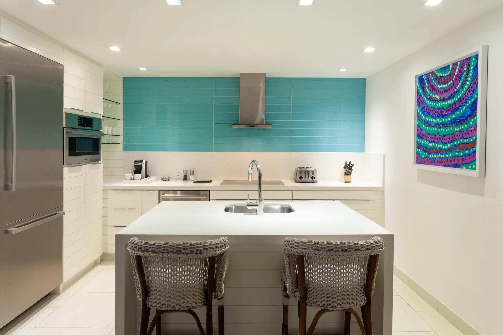 Suite kitchen with island seating and turquoise backsplash at Grand Hyatt Baha Mar.